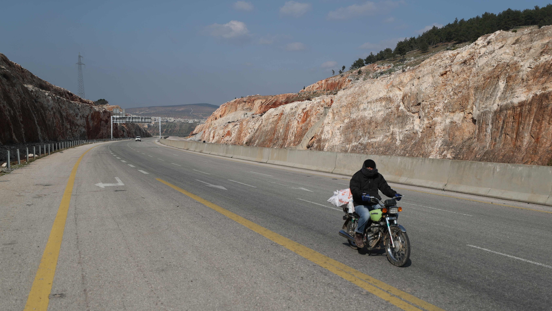 Ein Motorradfahrer auf der praktisch leeren Schnellstraße M4 in der Provinz Idlib. | AFP