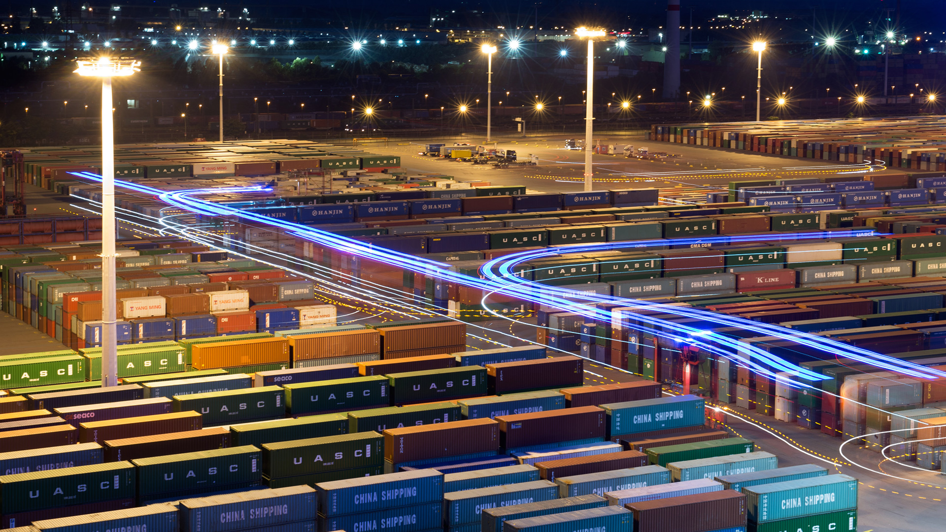 Hamburg: Hubwagen zum Umschlag von Containern fahren mit blauer Beleuchtung auf dem Terminal Eurogate im Hafen. | Bildquelle: dpa