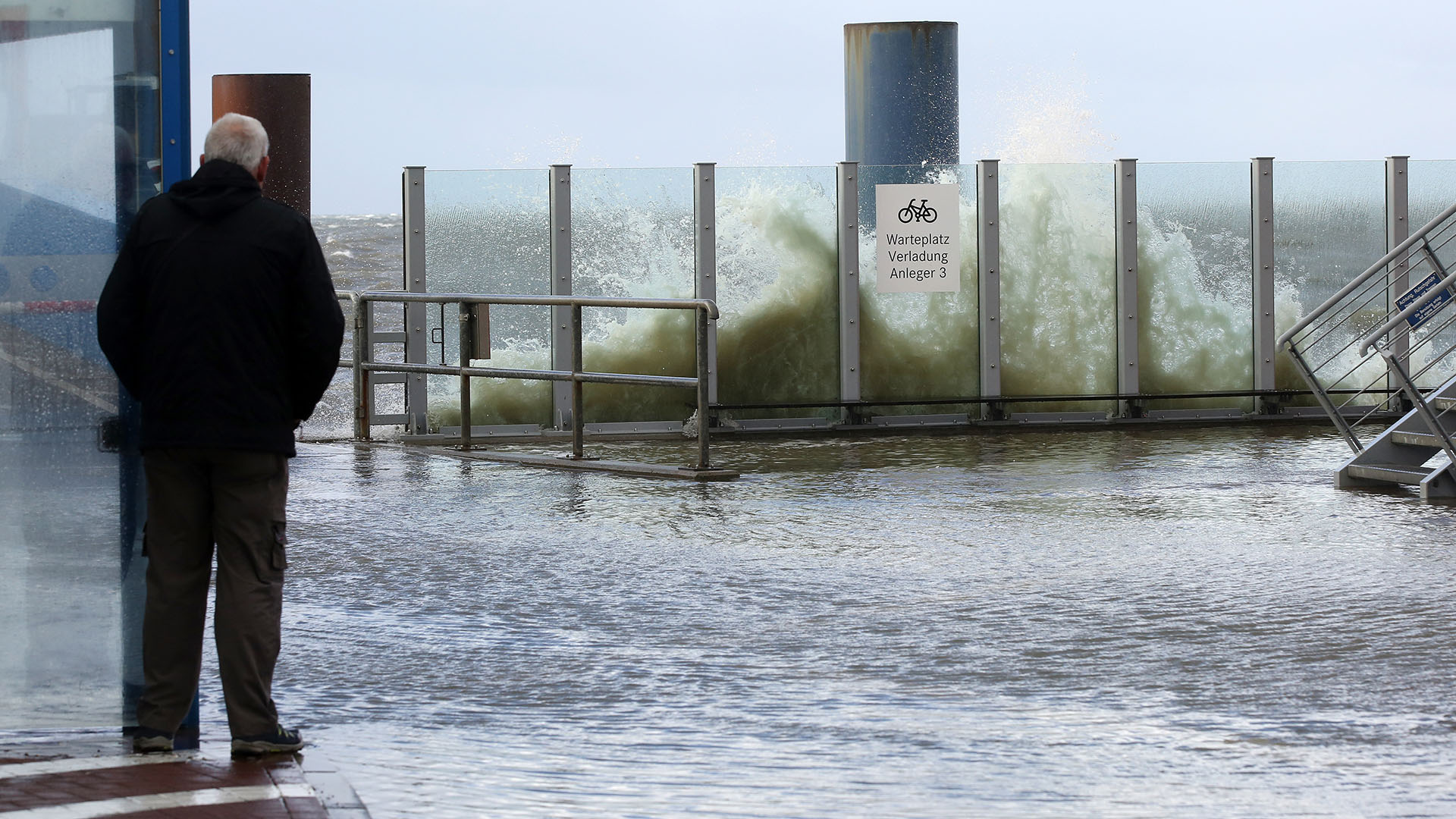 Die Gischt der Nordsee spritzt auf die überflutete Mole des Fähranlegers in Dagebüll.  | dpa