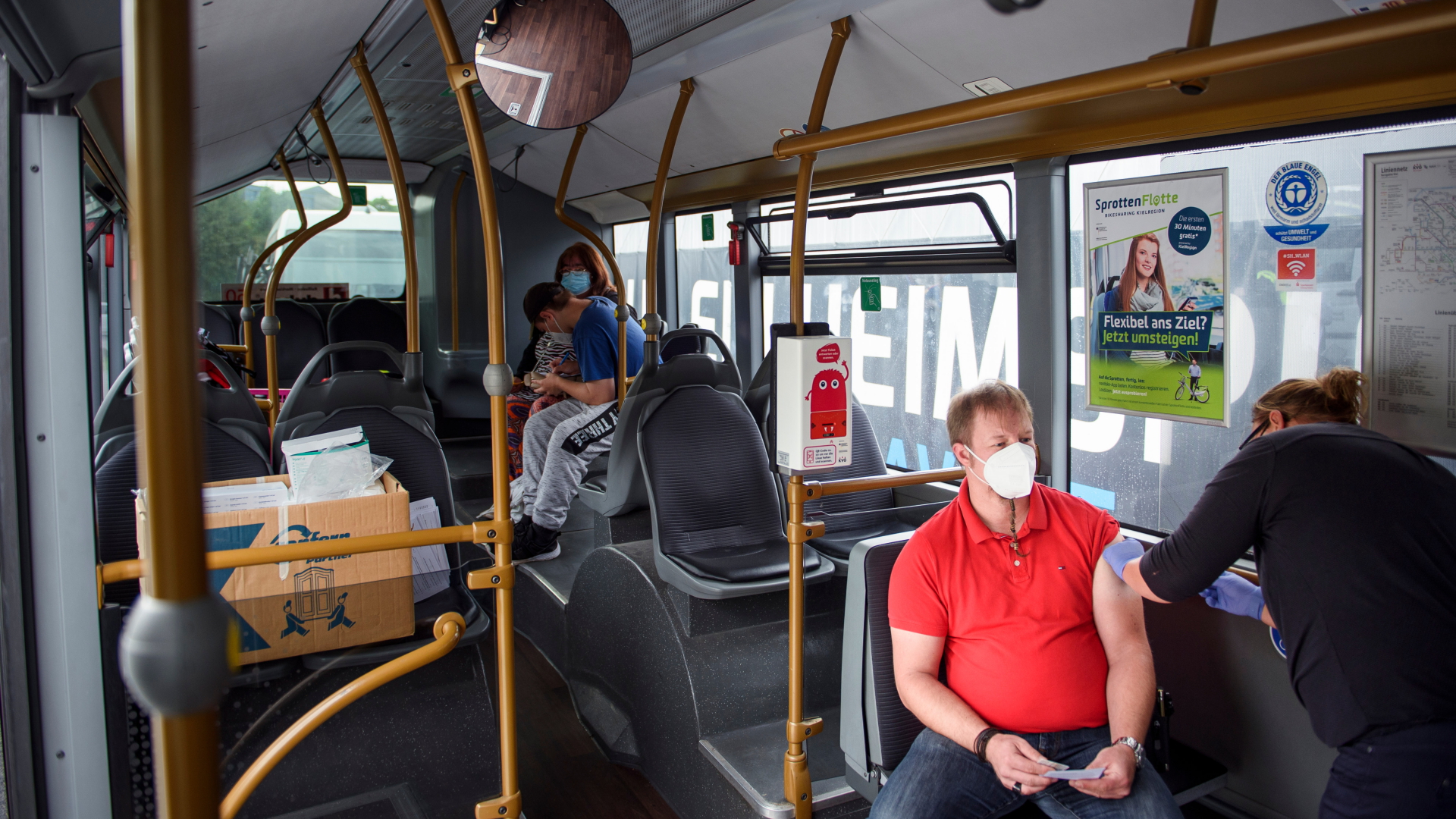Ein Mann lässt sich in einer mobilen Impfstation in einem Bus der Kieler Verkehrsbetriebe impfen.
