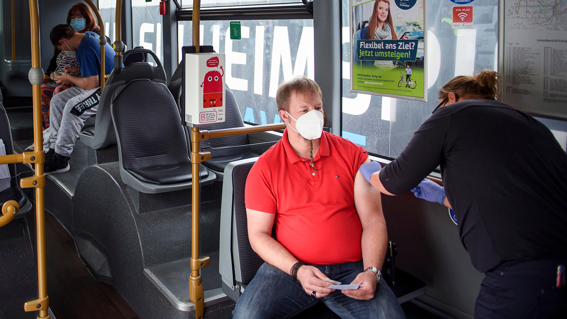Ein Mann lässt sich in einem Bus in Kiel impfen. | picture alliance/dpa