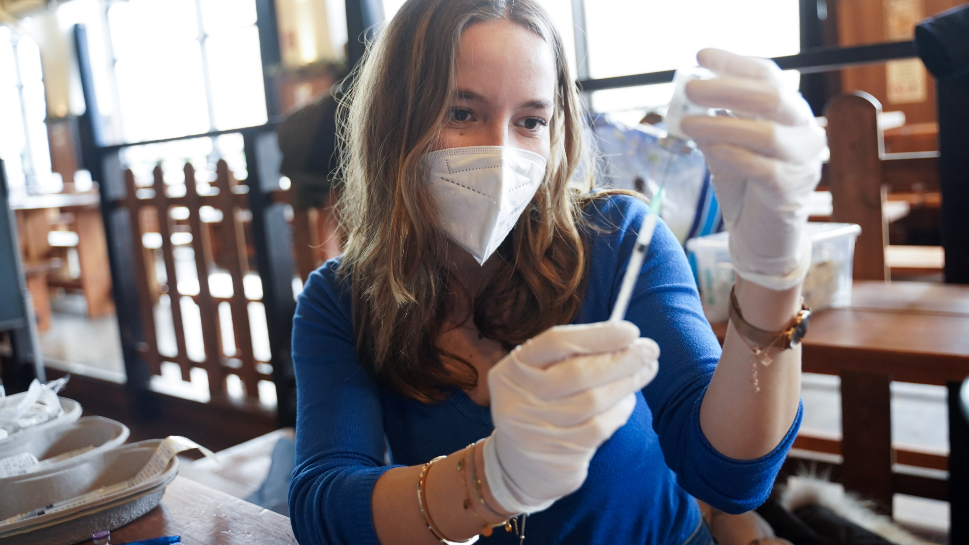 Eine Medizinstudentin bereitet eine Spritze für eine Corona-Impfung in einer Einrichtung für Obdachlose in Berlin vor.  | dpa