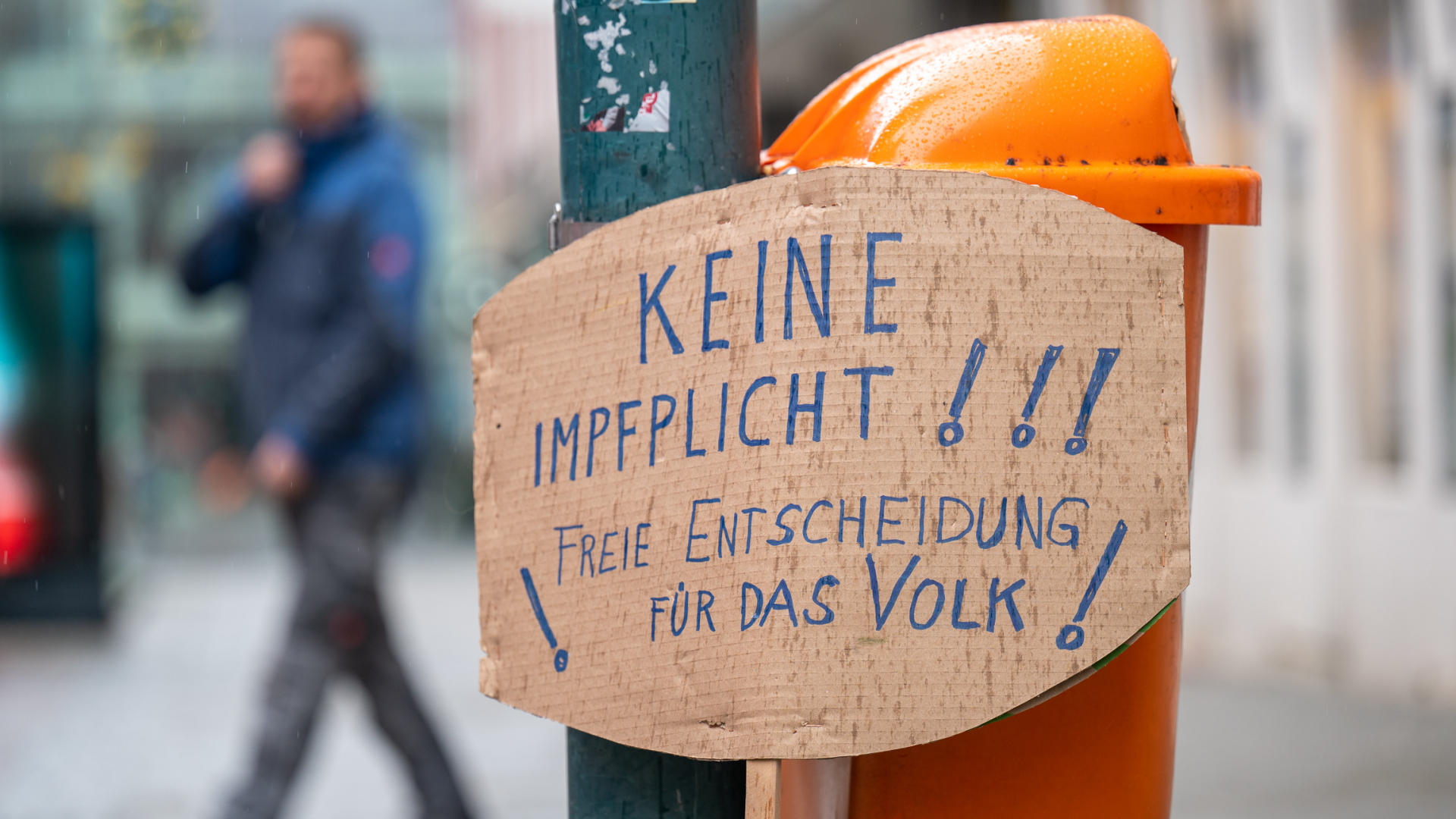 Ein Pappschild mit der Aufschrift "Keine Impfpflicht - freie Entscheidung für das Volk" an einem Mülleimer in Linz | dpa