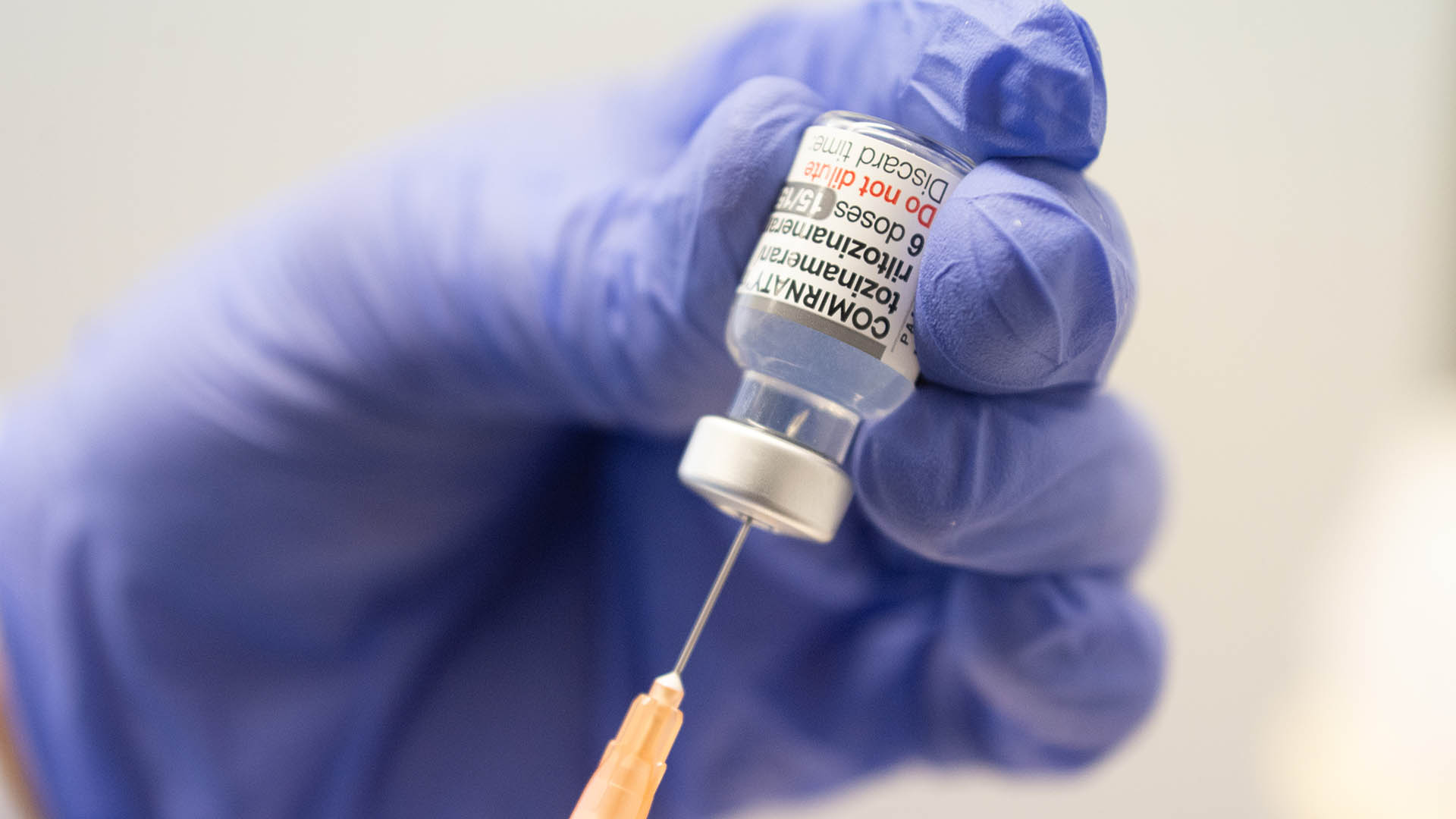 in Mitarbeiter zieht eine Spritze mit dem an die Omikron-BA.1-Variante angepassten Impfstoff Comirnaty von Biontech und Pfizer auf. 