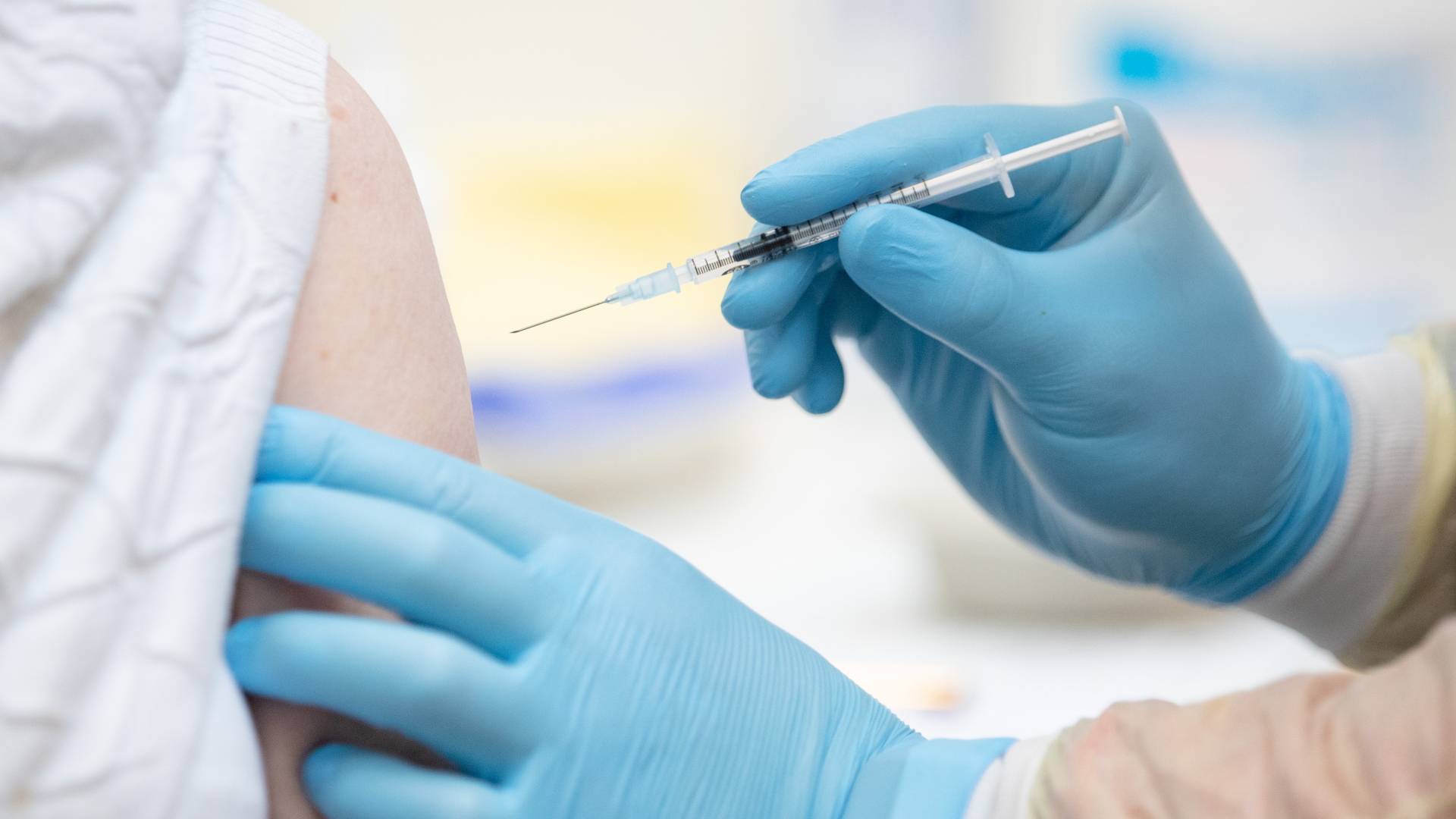 Eine Person wird in einem Impfzentrum geimpft