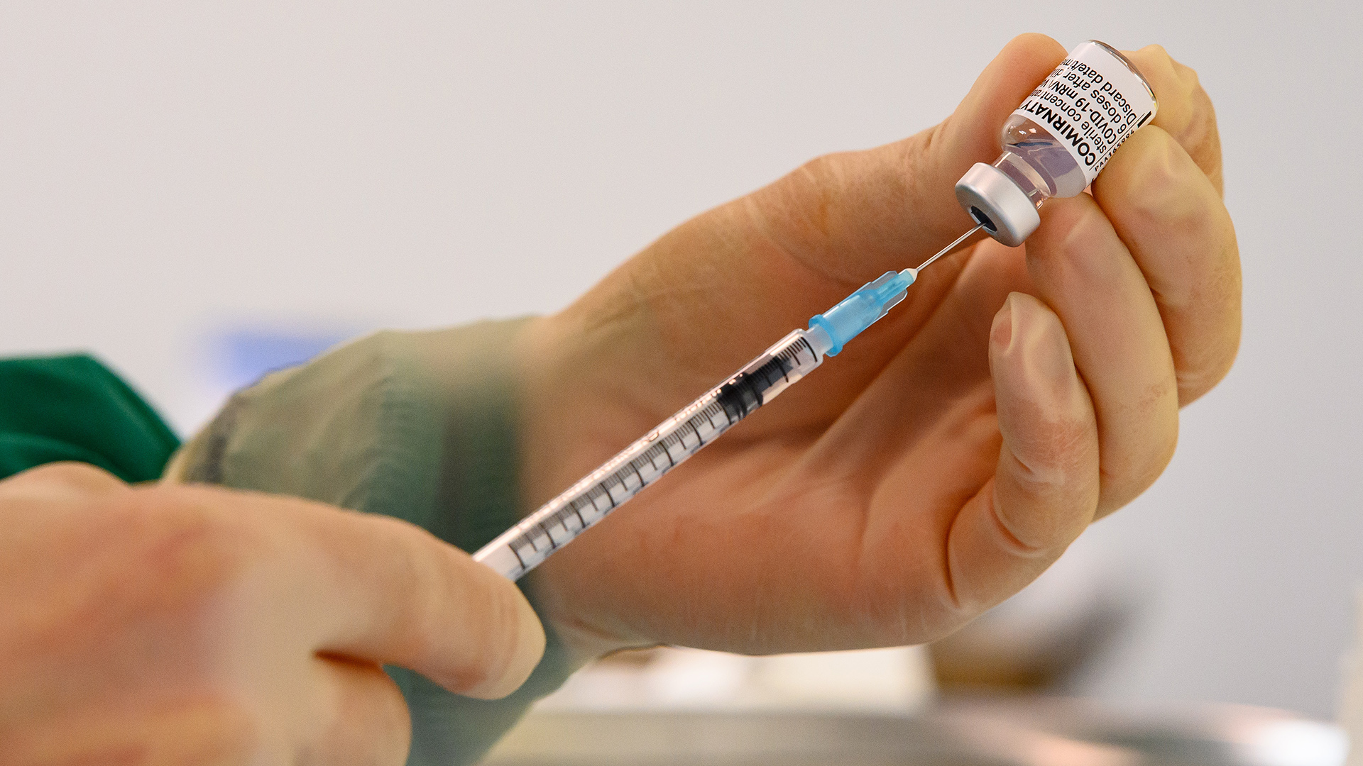 Eine medizinische Mitarbeiterin zieht den Impfstoff der Firma Biontech in eine Spritze. | picture alliance/dpa