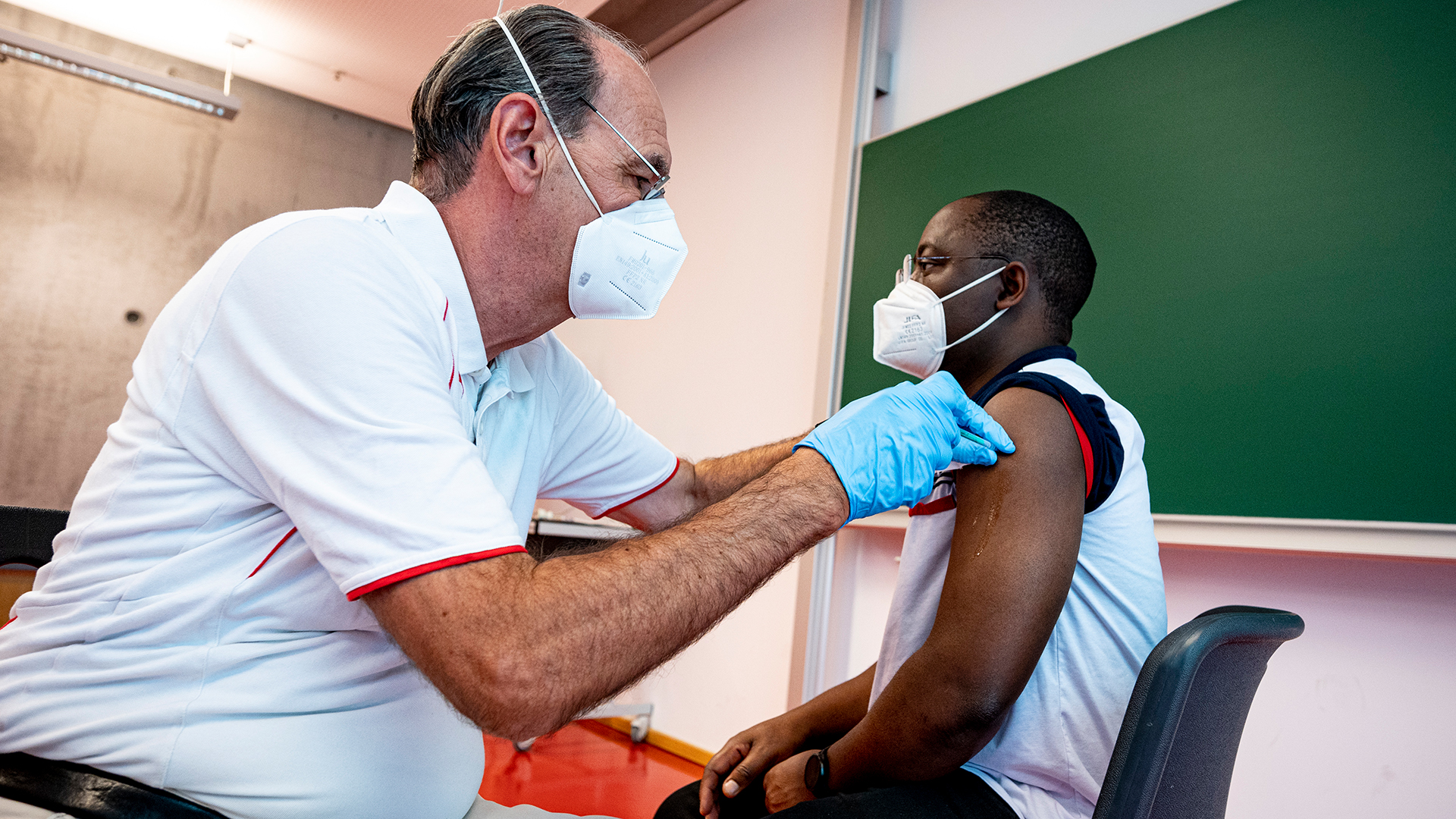 Ein Impfarzt impft an der Universität Potsdam einen Promovierenden gegen Corona. | dpa