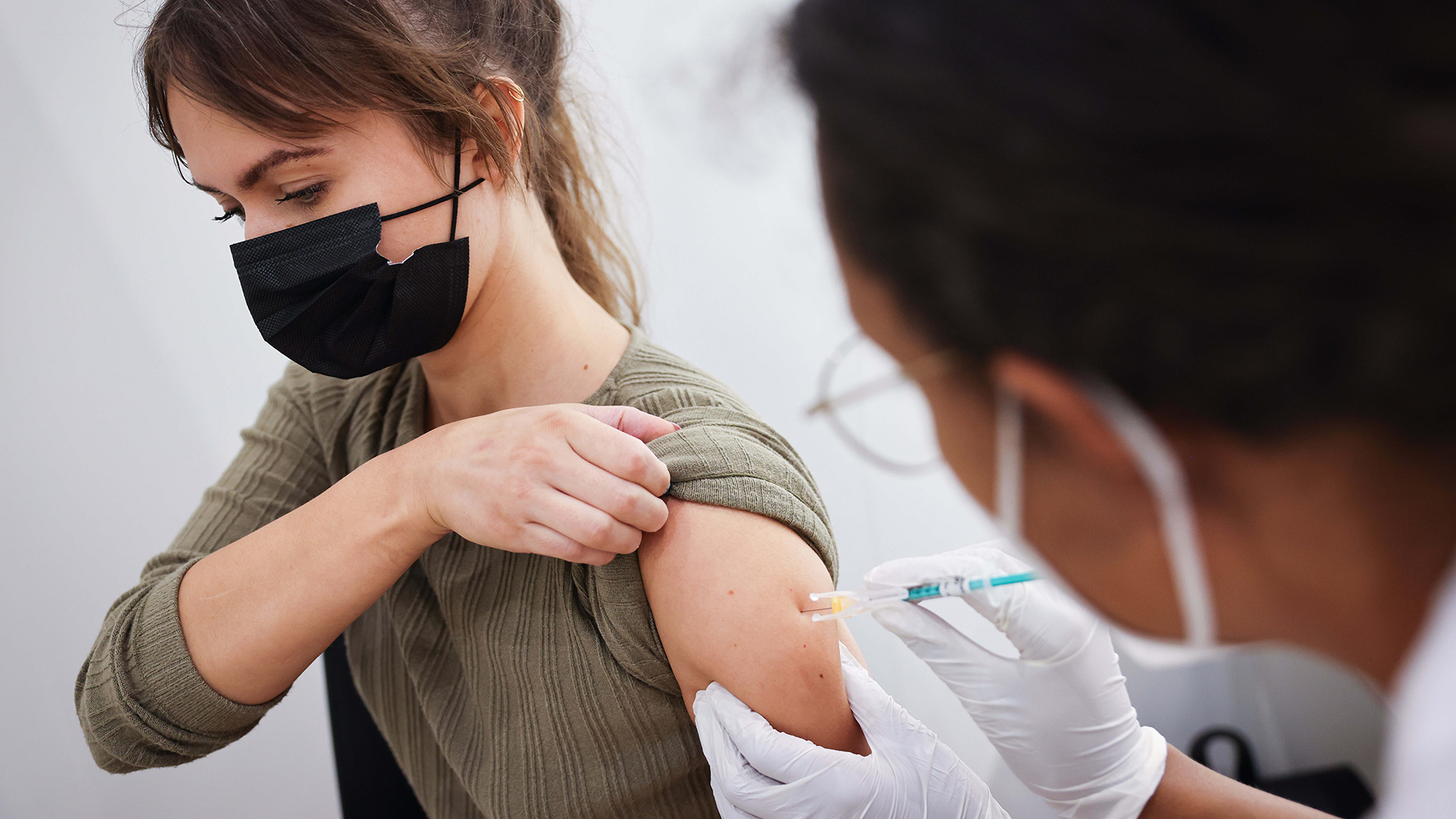 Eine Frau bekommt ihre Zweitimpfung mit dem Impfstoff von Biontech/Pfizer im Hamburger Impfzentrum in den Messehallen. | dpa