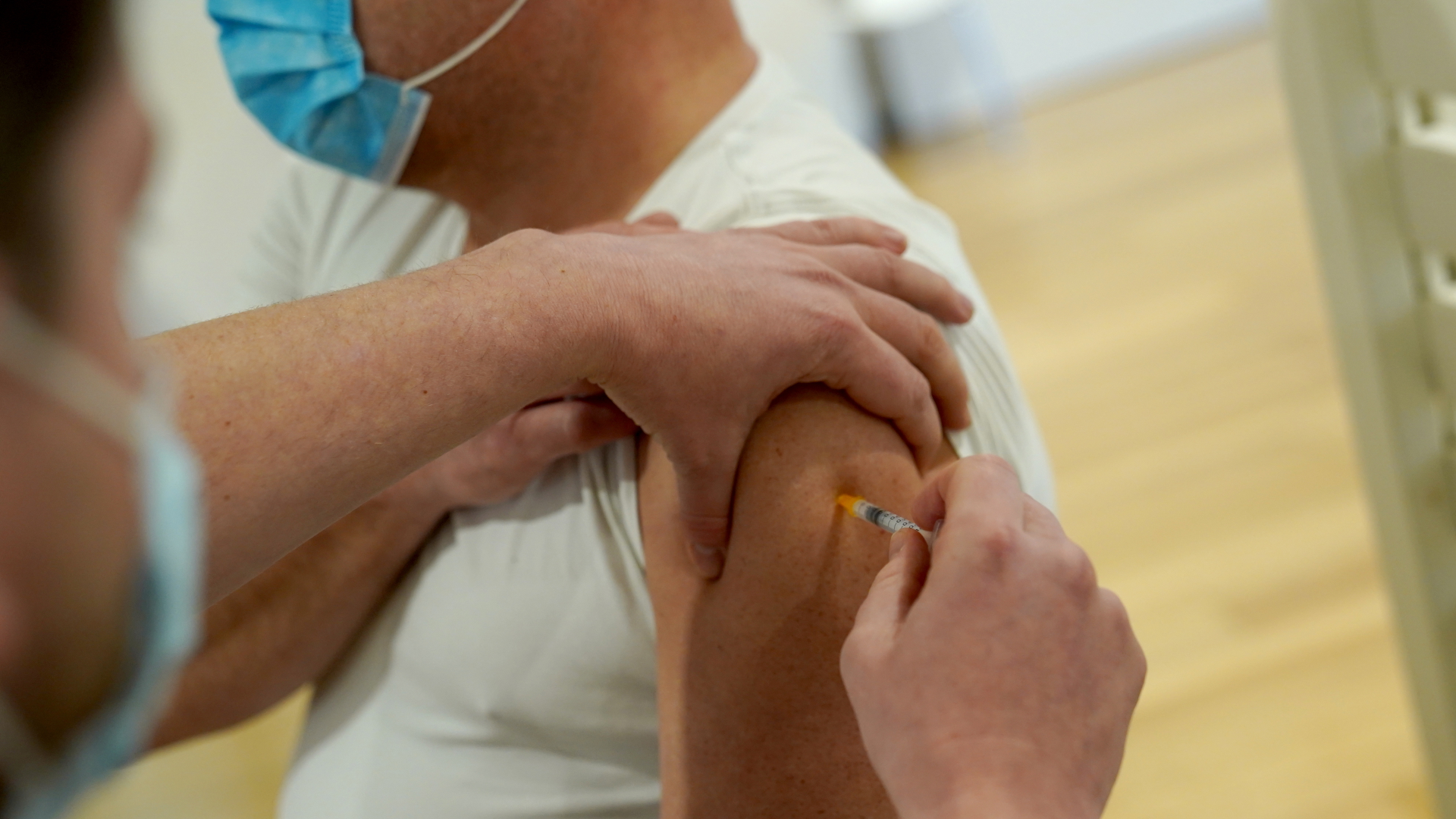 Ein Mann lässt sich mit Biontech während der Impfaktion in einem Hamburger Fitnessstudio impfen. | dpa