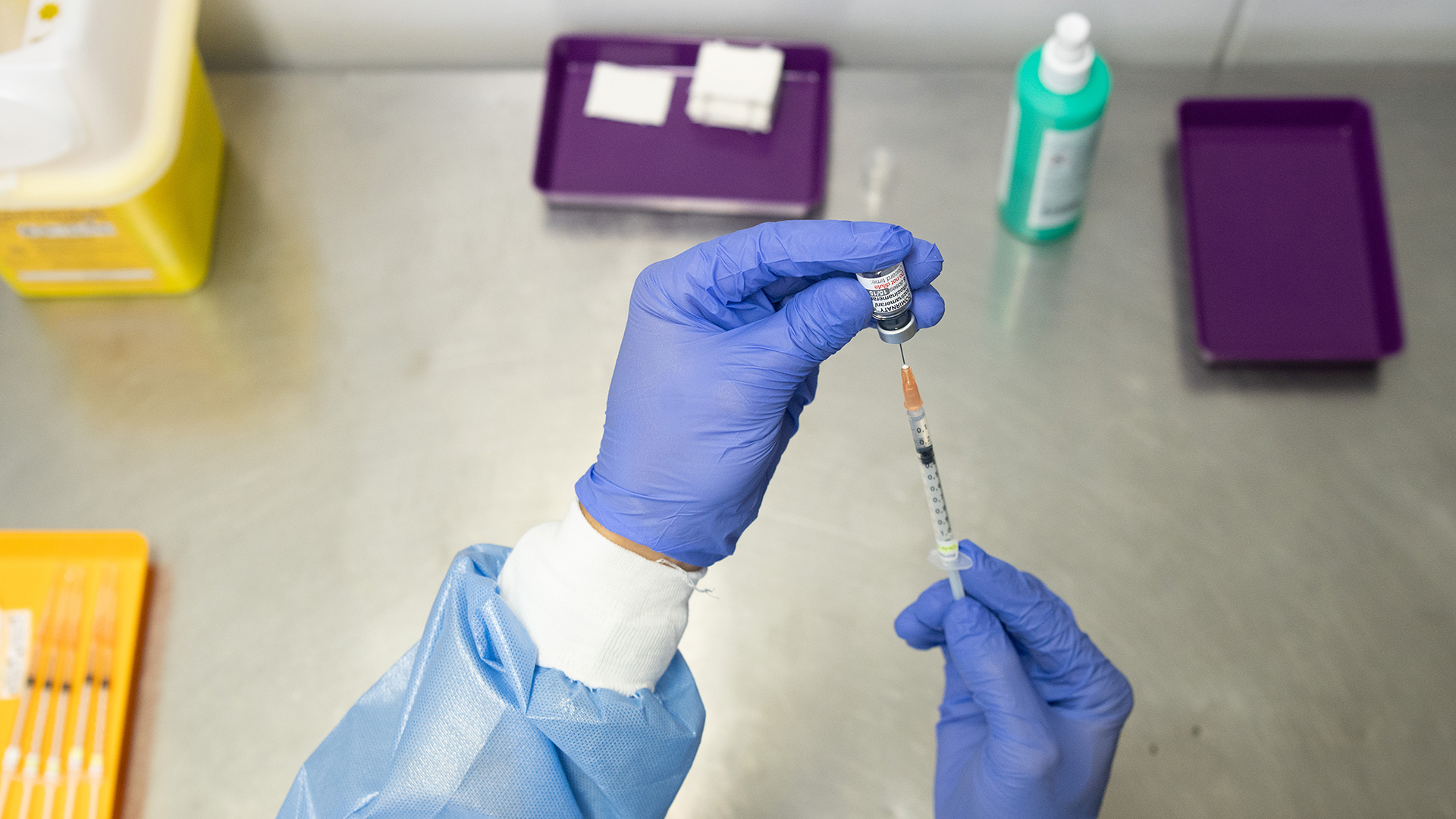 Ein Mitarbeiter zieht eine Spritze mit einem Impfstoff gegen Corona auf.