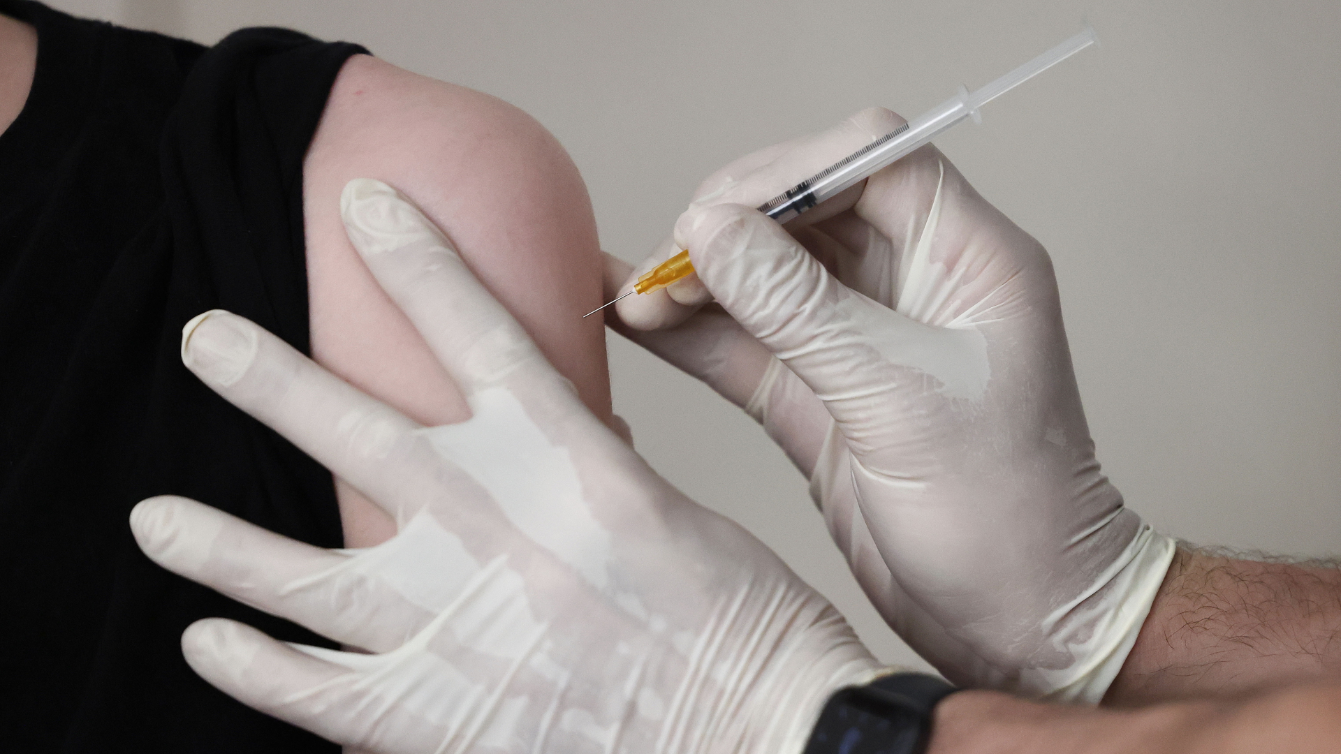 Ein Arzt verabreicht einem Jugendlichen eine Spritze mit einem Corona-Impfstoff. | dpa