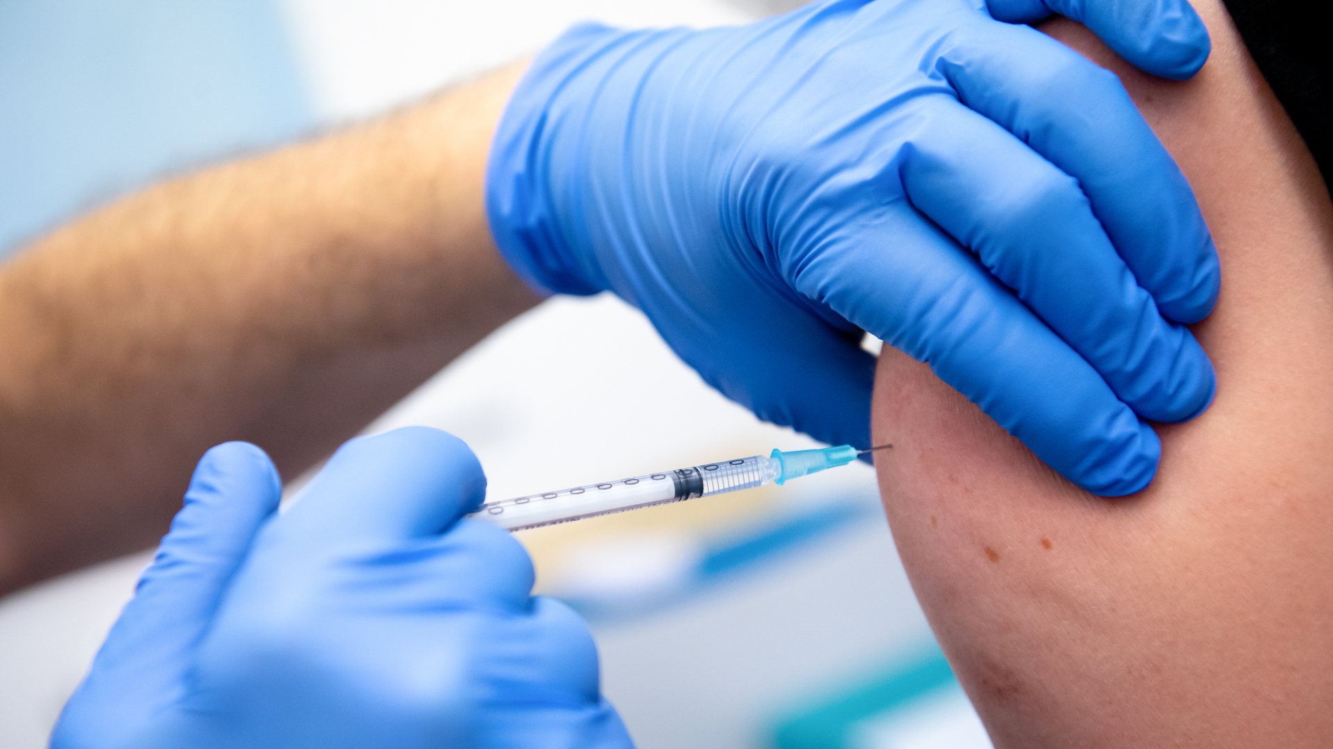 Ein Mitarbeiter der Asklepios Klinik im bayerischen Gauting wird von einem Kollegen mit dem Corona-Impfstoff von Biontech/Pfizer geimpft. | dpa