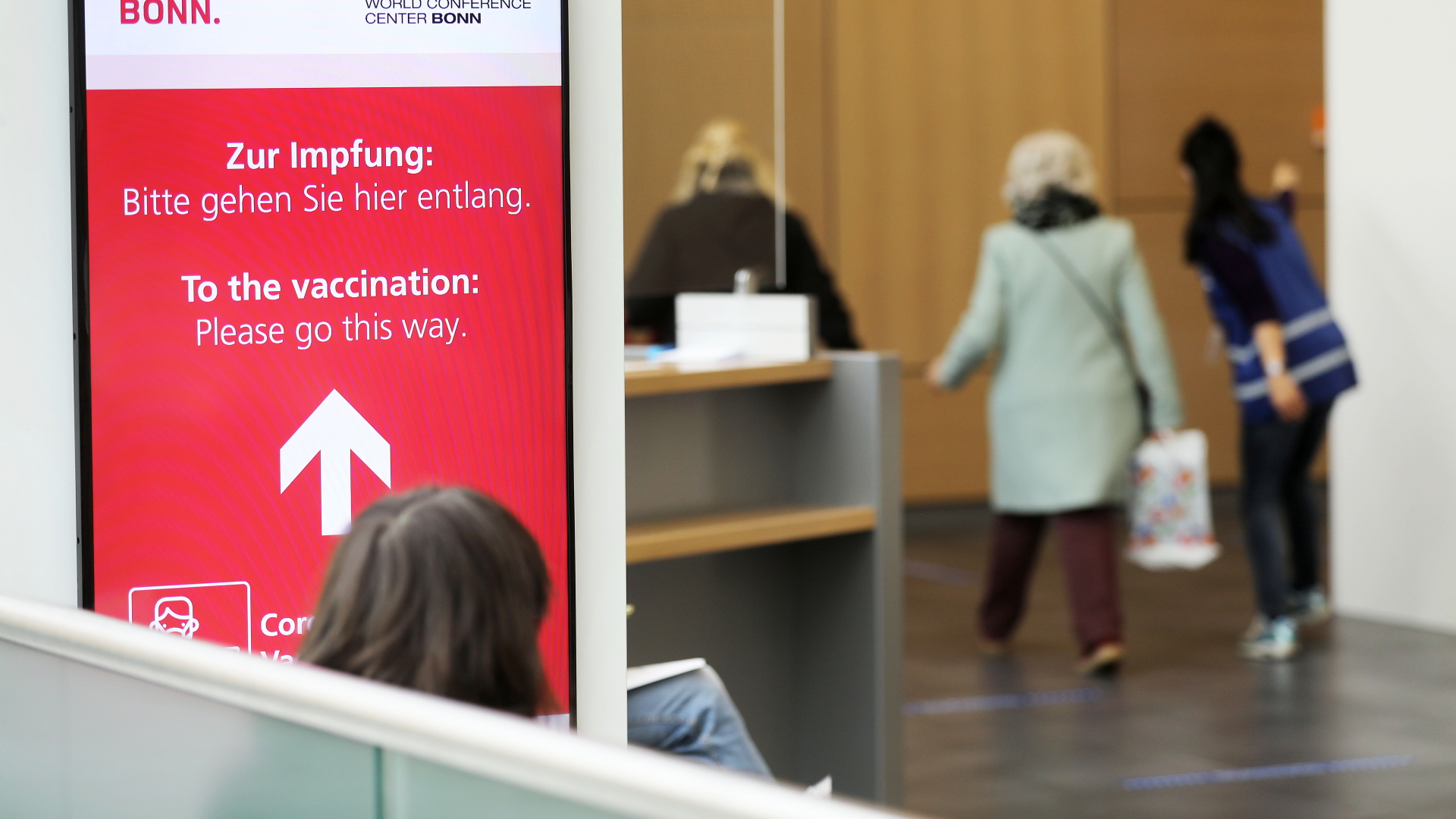 Frauen gehen im Corona-Impfzentrum zur Impfung. In Nordrhein-Westfalen geht die nächste Impfgruppe an den Start