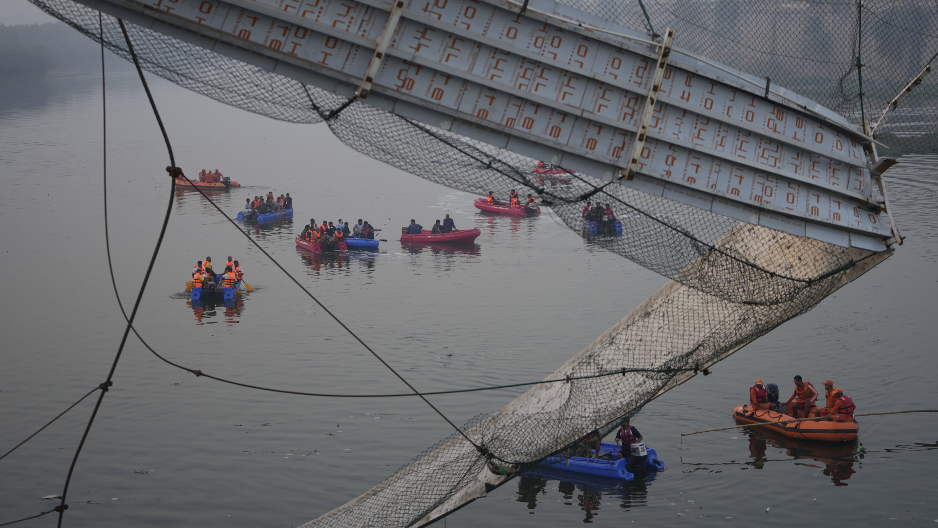 Rettungskräfte in Booten unter der zusammengestürzten Brücke | AP