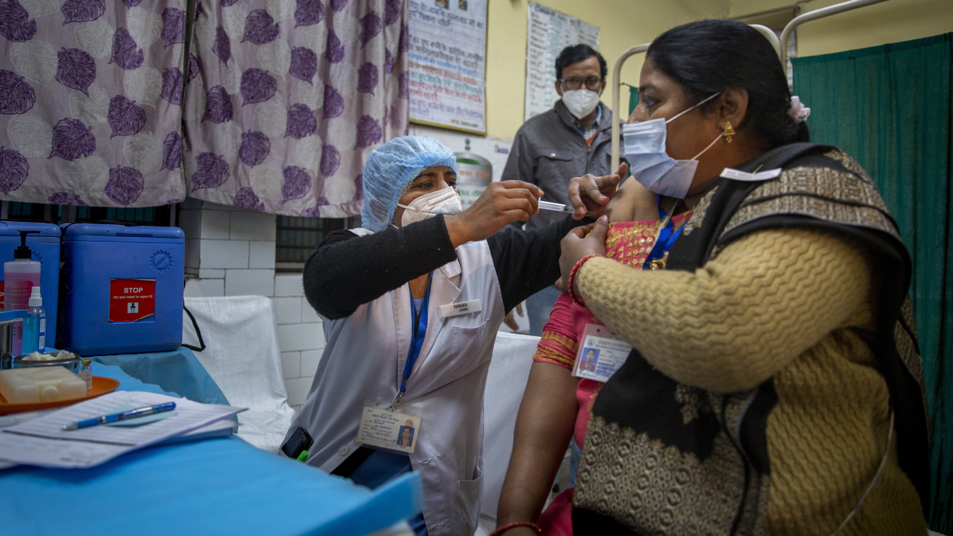 Eine Frau bekommt von einer Mitarbeiterin in einem Impfzentrum in Neu-Delhi einen Corona-Impfstoff verabreicht. | AP
