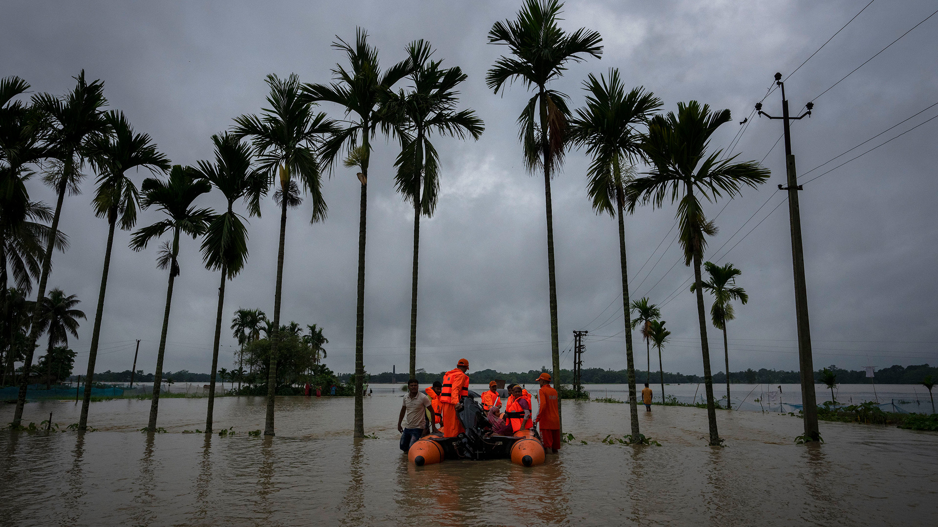 Mitarbeiter der "National Disaster Response Force" (NDRF) retten von der Flut betroffene Bewohner im Dorf Korora, westlich von Gauhati, Indien. | AP