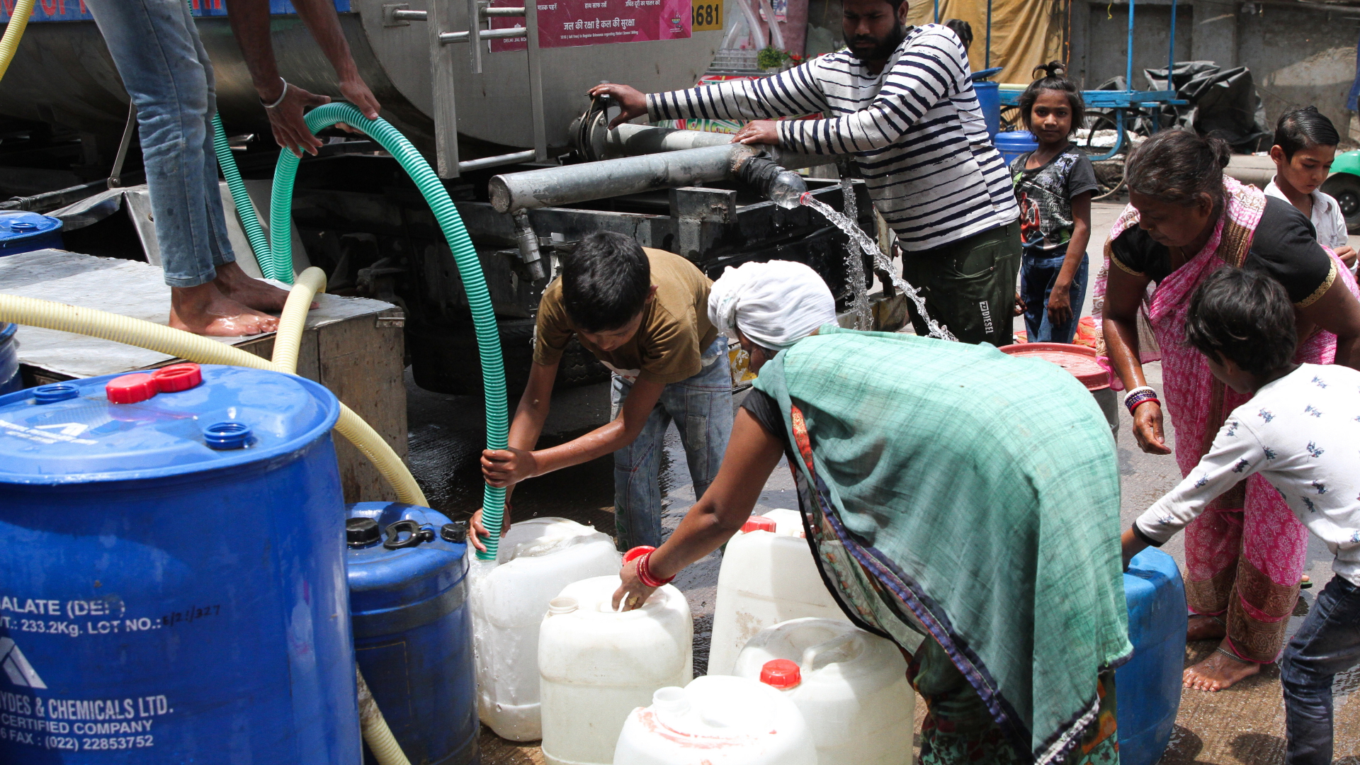 Anwohner in Neu-Delhi holen mit Kanistern an einem heißen Sommertag Trinkwasser aus einem Tank.  | dpa