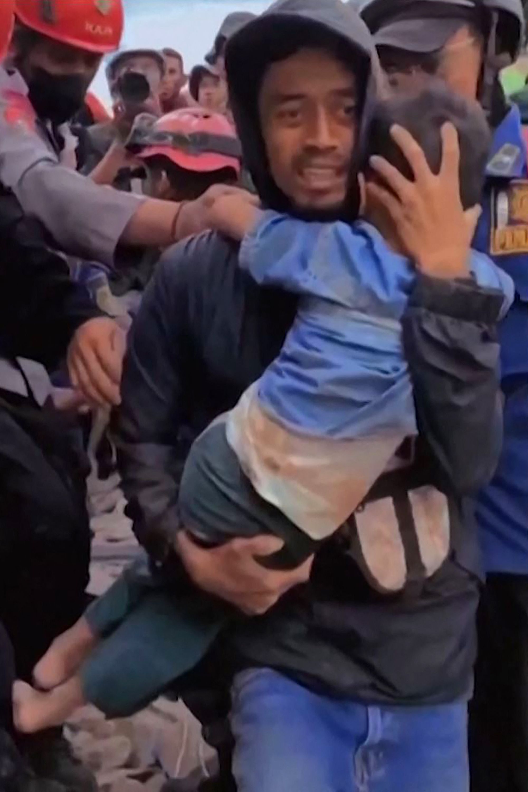 Ein Mann trägt ein Kind auf dem Arm. | AFP
