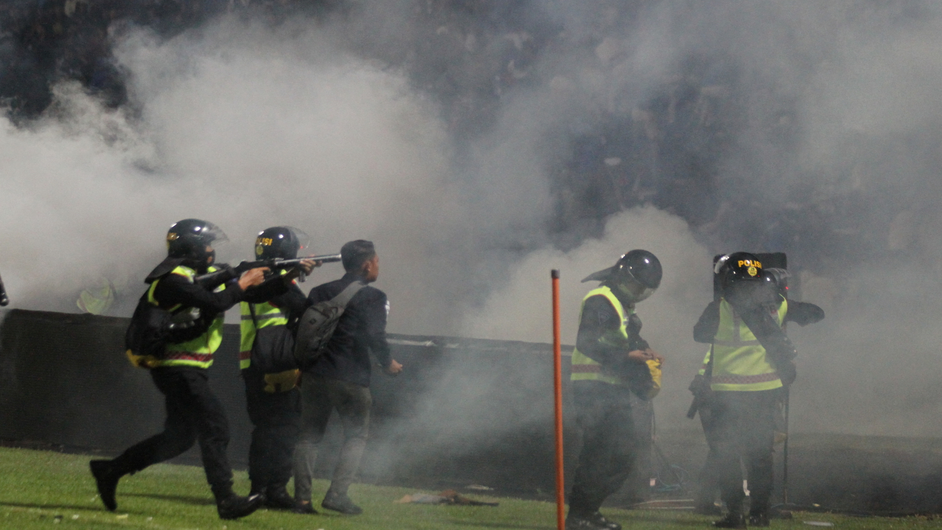 Die Polizei setzt Tränengas ein, um Fußballfans zu zerstreuen, die nach einem Spiel zwischen Arema FC und Persebaya Surabaya im Kanjuruhan-Stadion in Malang das Spielfeld betreten. | via REUTERS