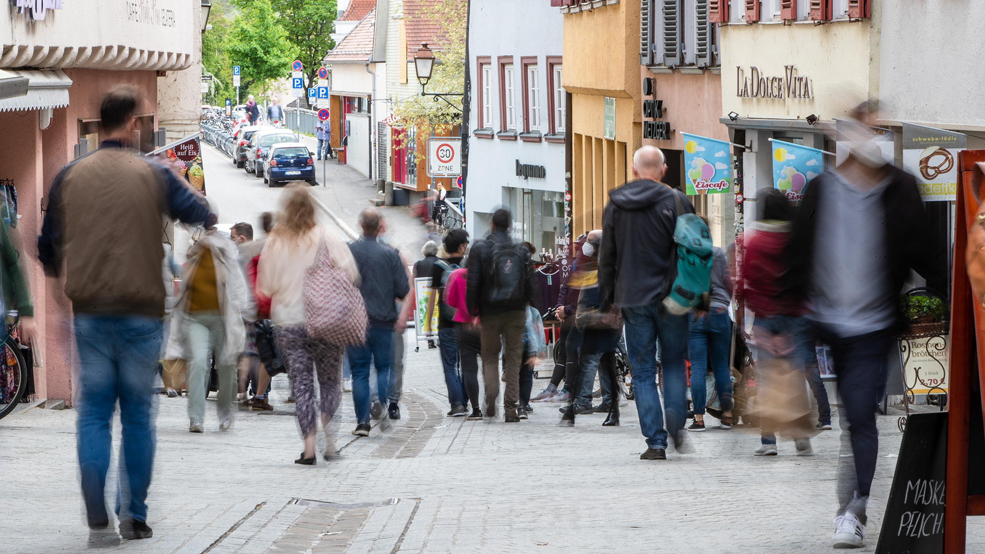 Menschen gehen durch die Fußgängerzone Tübingens.