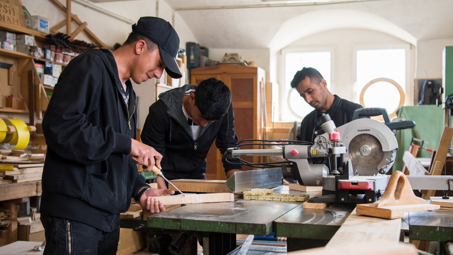 Drei junge Geflüchtete arbeiten in einer Holzwerkstatt in der Moritzburger Produktionsschule in Sachsen. (Archivbild vom 17.04.2018) | dpa
