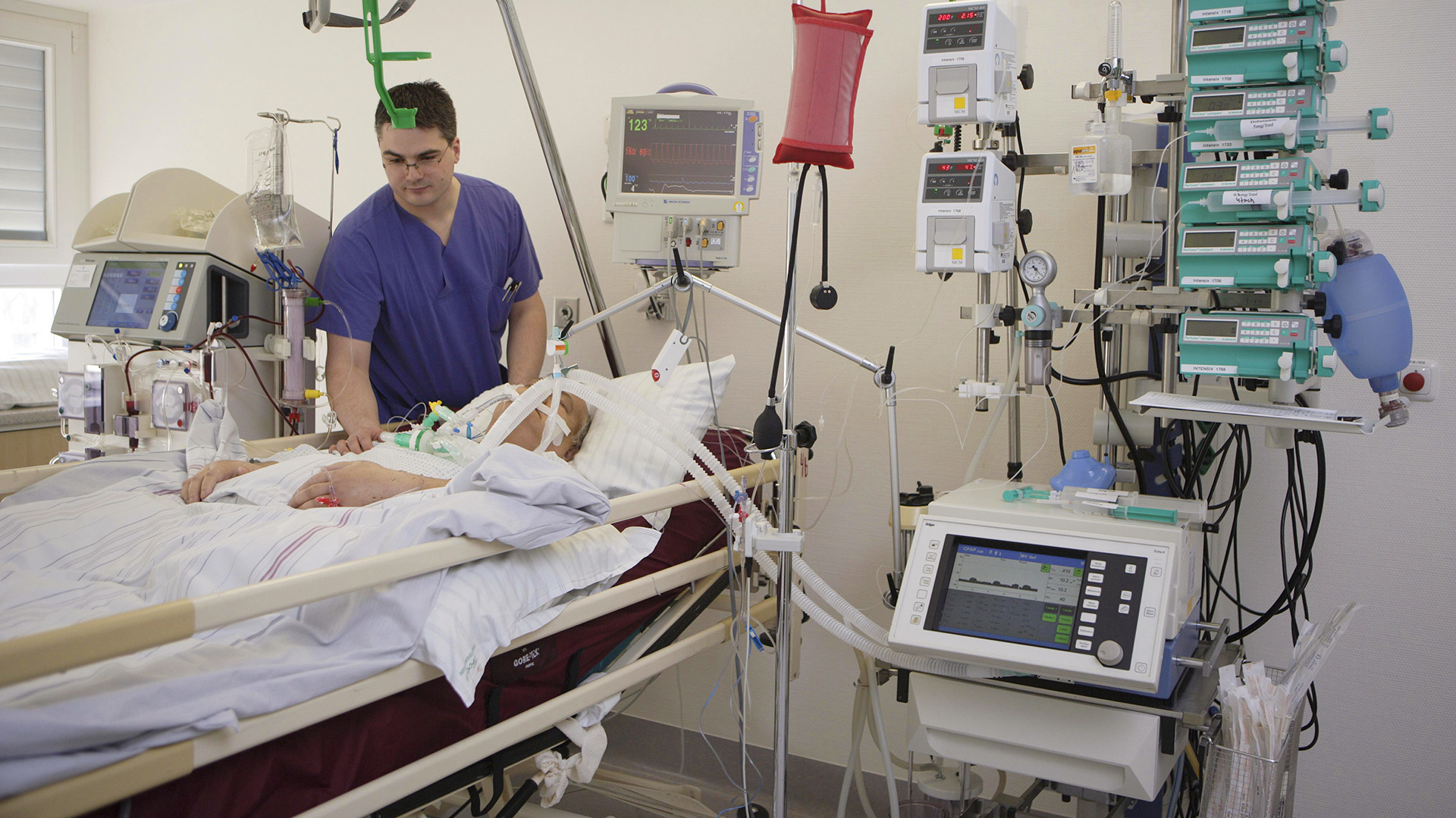 Ein Krankenpfleger während seiner Arbeit auf der Intensivstation in einem Krankenhaus | picture alliance / imageBROKER