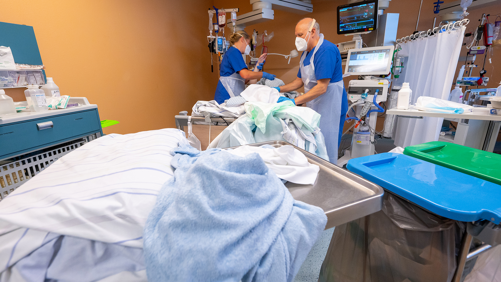 Pflegekräfte arbeiten mit einem Patienten in einem Intensivbett-Zimmer der Asklepios Klinik Gauting.