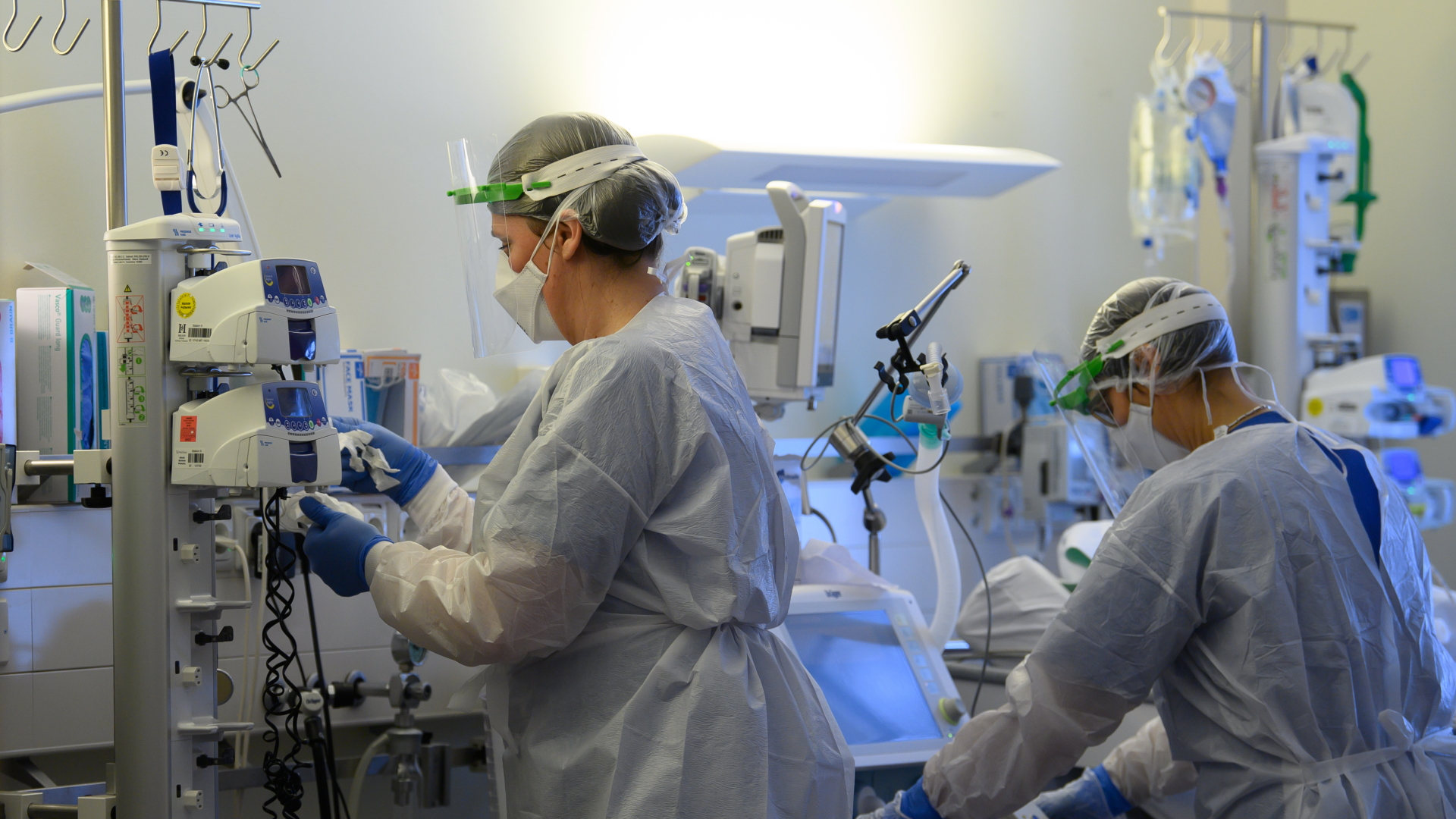 Sachsen, Pulsnitz: Intensivpflegerinnen sind in Schutzkleidungen auf der Covid-19 Intensivstation in der VAMED Klinik Schloss Pulsnitz mit der Versorgung von Corona-Patienten beschäftigt.