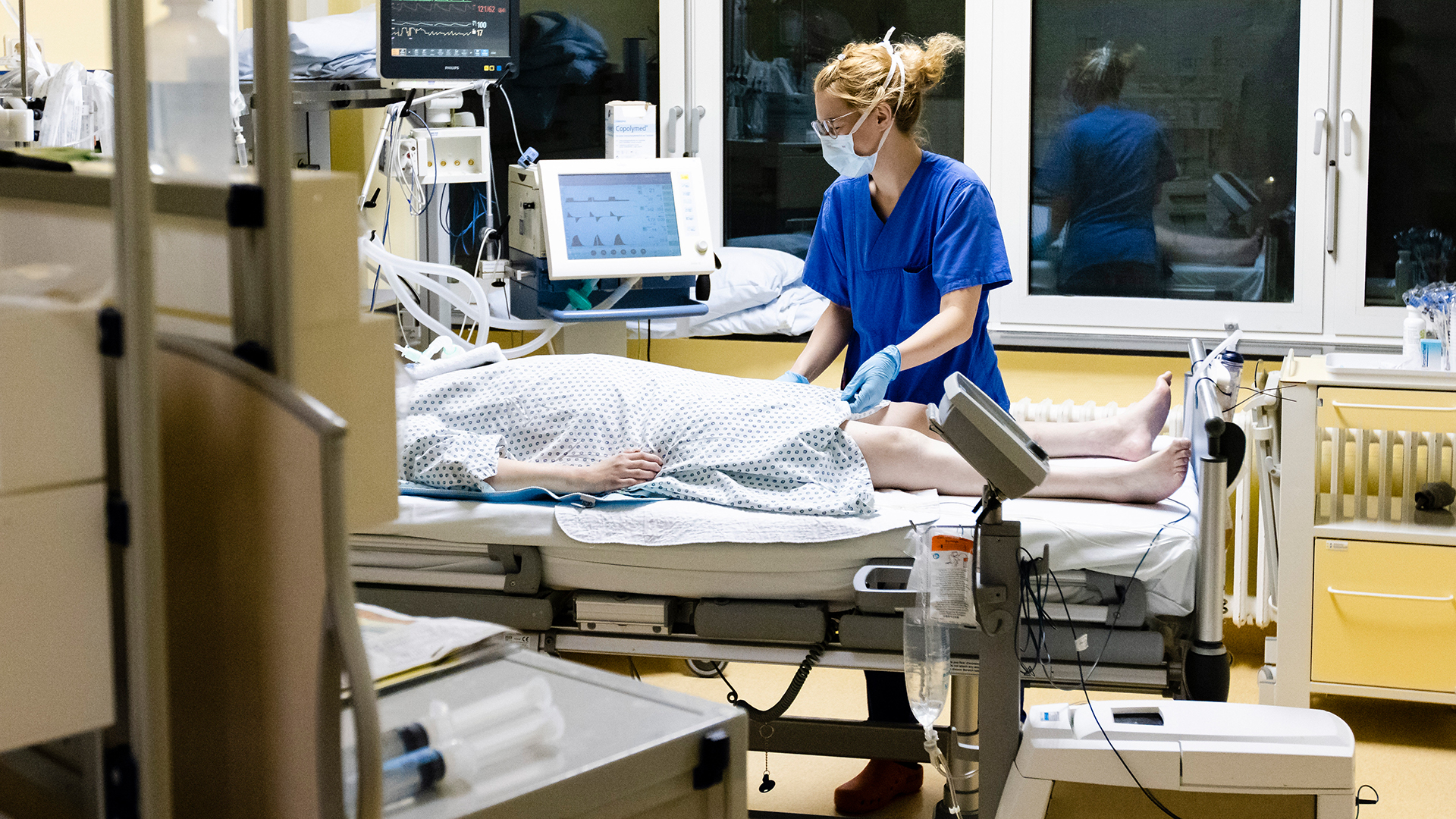 Eine Krankenschwester steht auf der Intensivstation am Universitätsklinikum Schleswig-Holstein am Bett einer Corona-Patientin.  | dpa