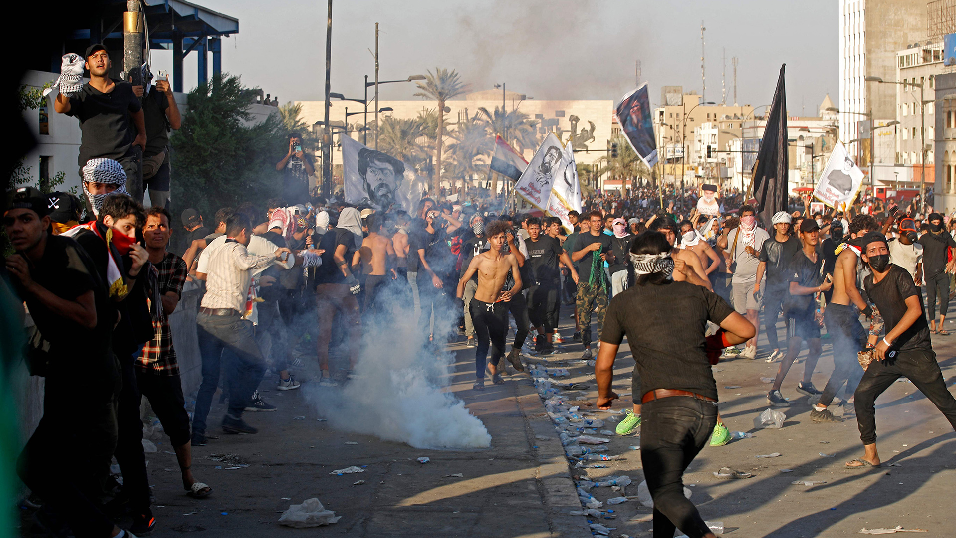 Irakische Demonstranten reagieren an der al-Jumhuriya-Brücke in Bagdad auf Tränengas. | AFP