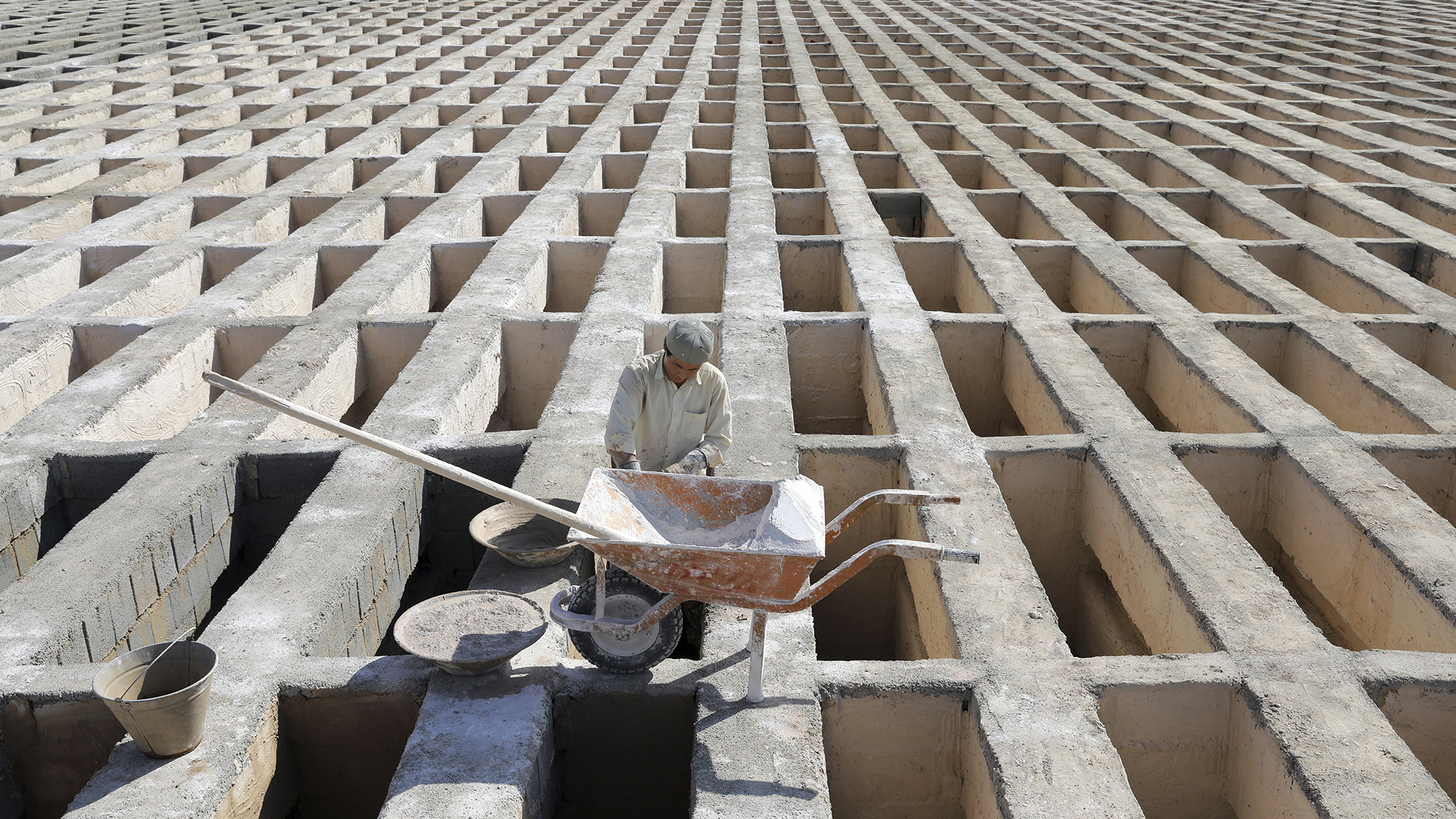 Ein Arbeiter mit Schubkarre bei der Schaffung neuer Gräber auf dem Behesht-e Zahra Friedhof | picture alliance / ASSOCIATED PR
