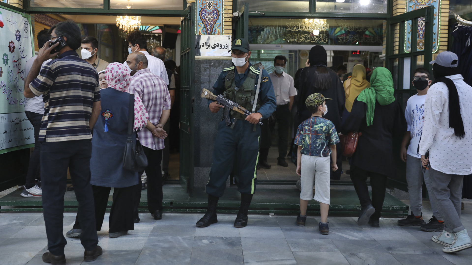 Menschen warten vor einem Wahllokal in Teheran. | AP