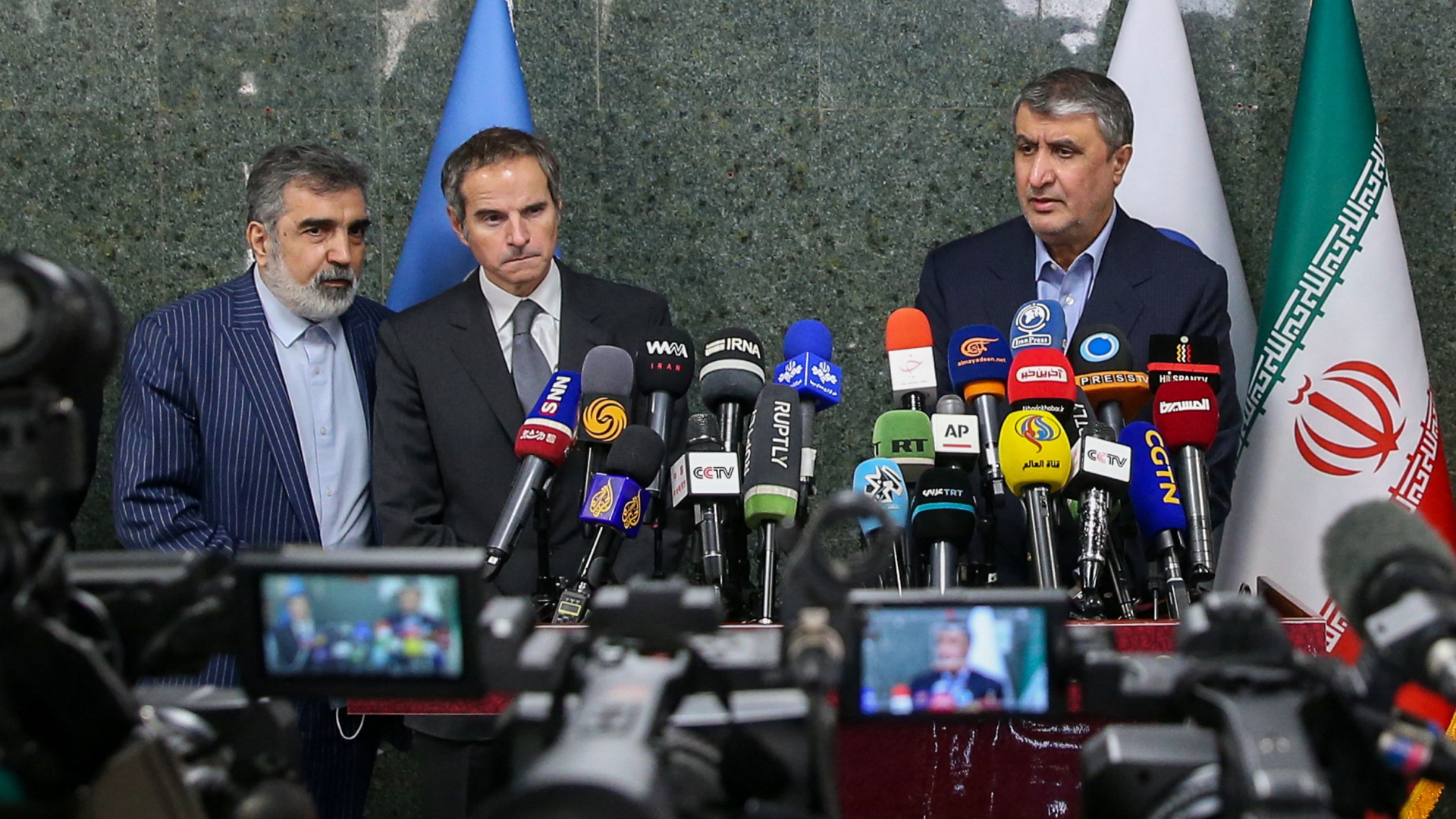IAEA-Chef Rafael Grossi (m.) und der Leiter der iranischen Atombehörde, Mohammad Eslami (r.) bei einer gemeinsamen Pressekonferenz. | AFP