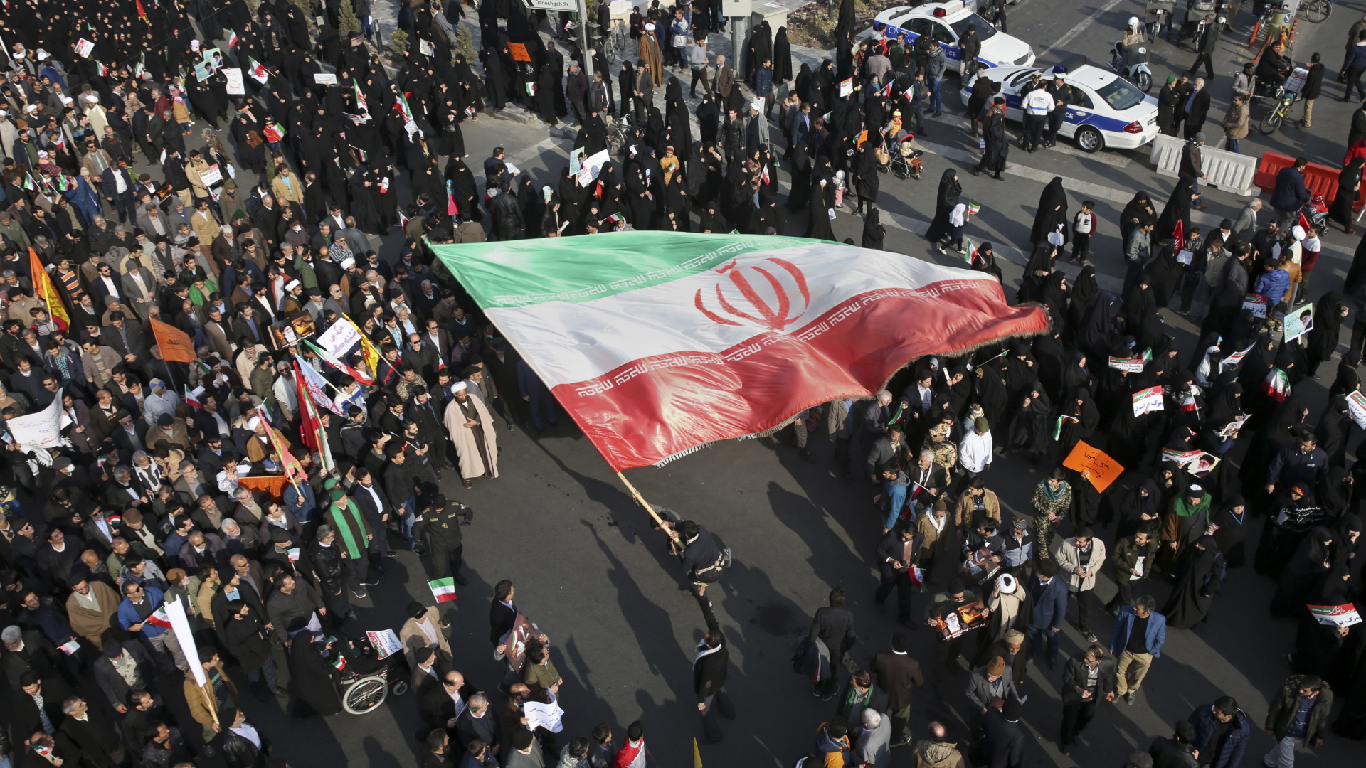 Ein Demonstrant im Iran schwenkt eine riesige iranische Flagge während einer Demonstration von Regierungsanhängern.  | dpa