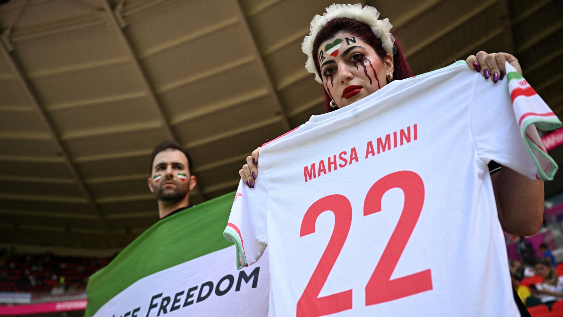 Eine Frau erinnert vor dem WM-Spiel gegen Wales mit einem Trikot an Mahsa Amini. | REUTERS