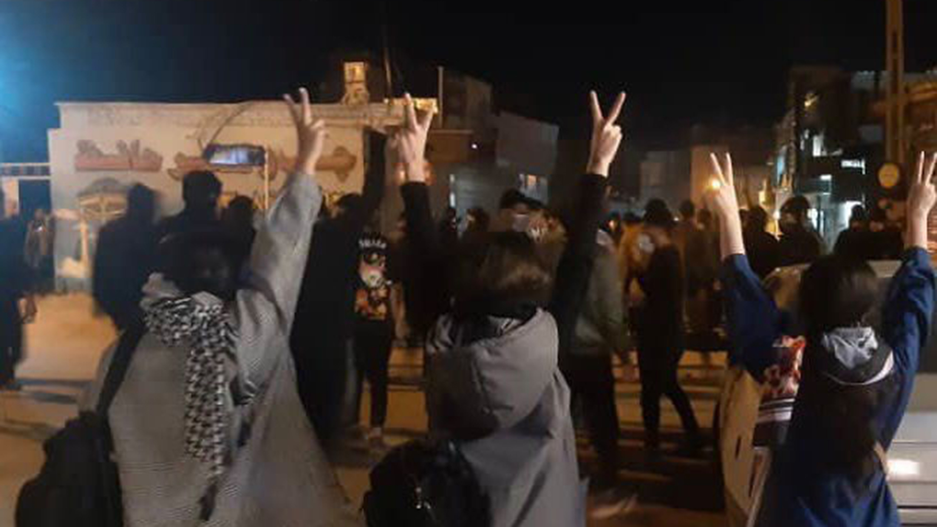 Protestierende Frauen ohne das vorgeschriebene Kopftuch heben ihre Hände und zeigen das Victory-Zeichen (Archivbild). | dpa