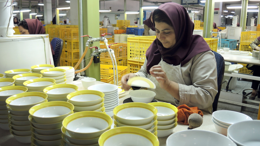 Eine Frau verziert in Isfahan im Iran Schüsseln aus Porzellan