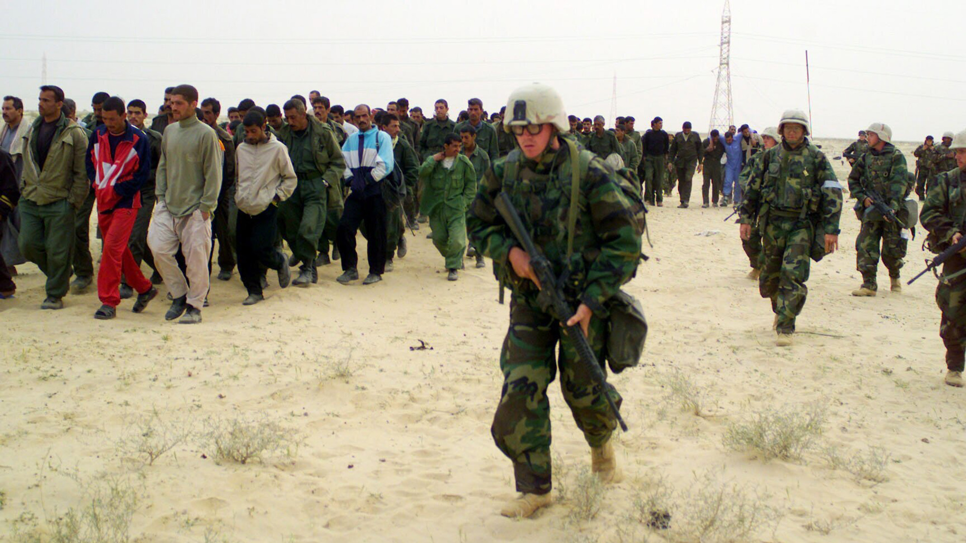 US-Marines eskortieren während der Operation Iraqi Freedom gefangene Kriegsgefangene in ein Lager in der irakischen Wüste (Archivfoto vom 21.03.2003). | picture-alliance / dpa