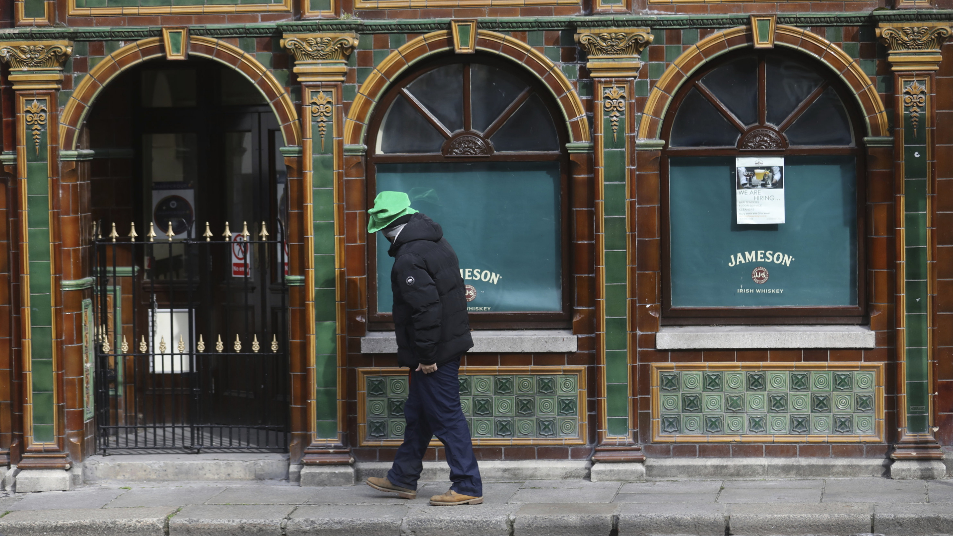 Ein Mann läuft im März 2021 in Dublin an einem geschlossenen Pub vorbei. | AP