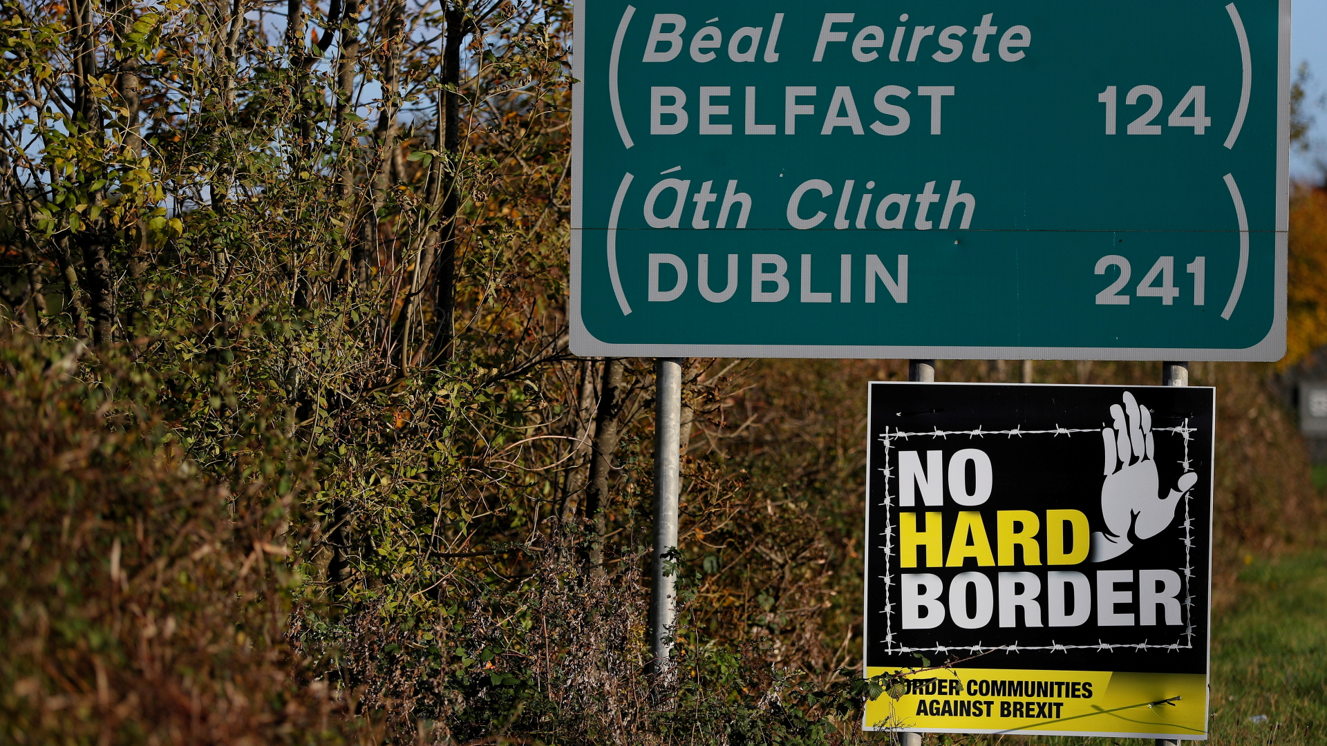 In der Nähe der Grenze zwischen Irland und Nordirland lehnt ein Plakat unter einem Verkehrsschild eine harte Grenze ab. | REUTERS