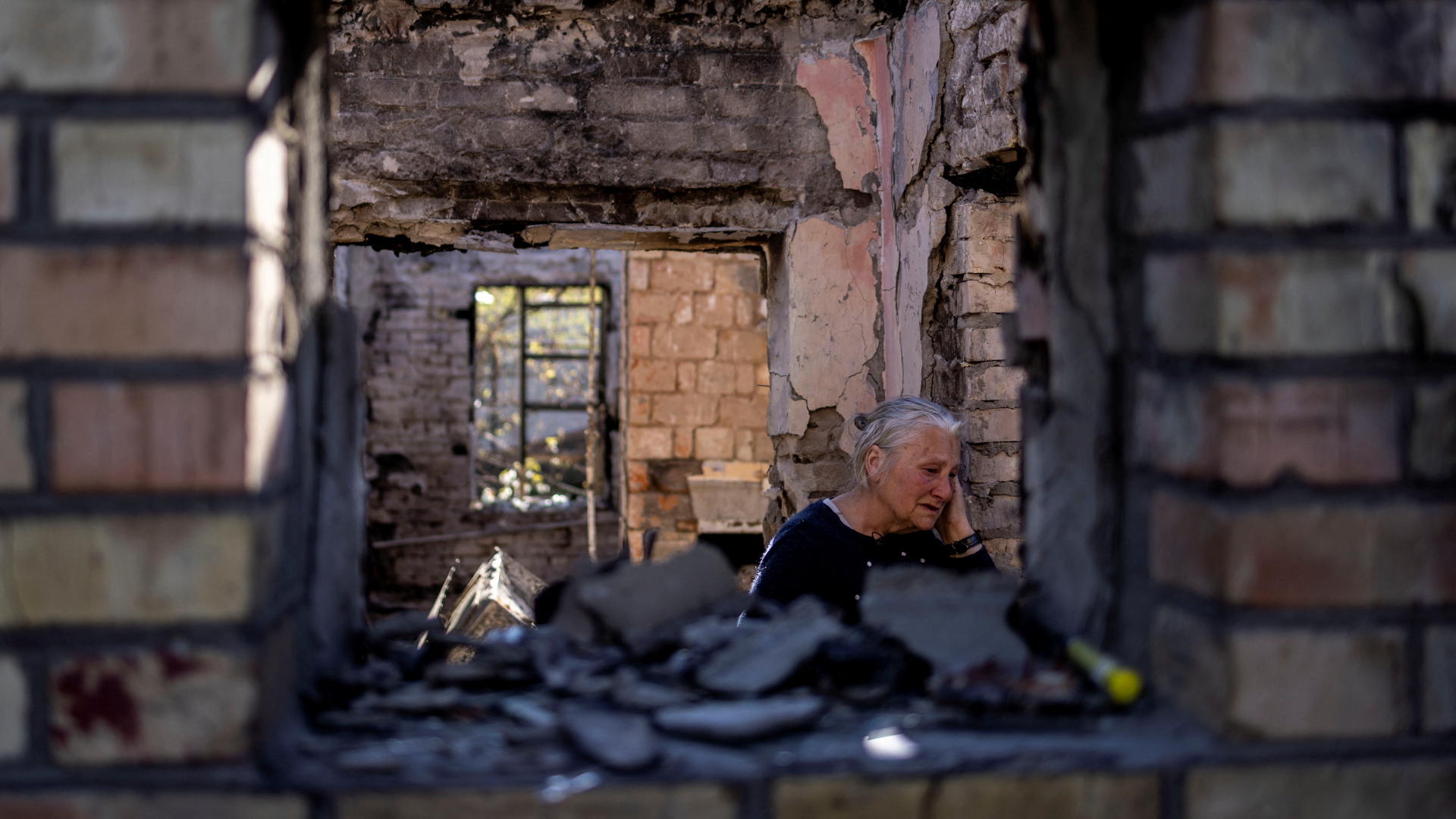 Ein Bewohnerin der Stadt Irpin, Ukraine, in ihrem zerstörten Haus. | REUTERS
