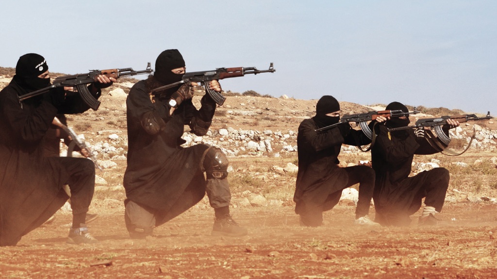 Vier IS-Kämpfer knien mit angelegten Gewehren in Rakka, Syrien. | picture alliance / ZUMAPRESS.com