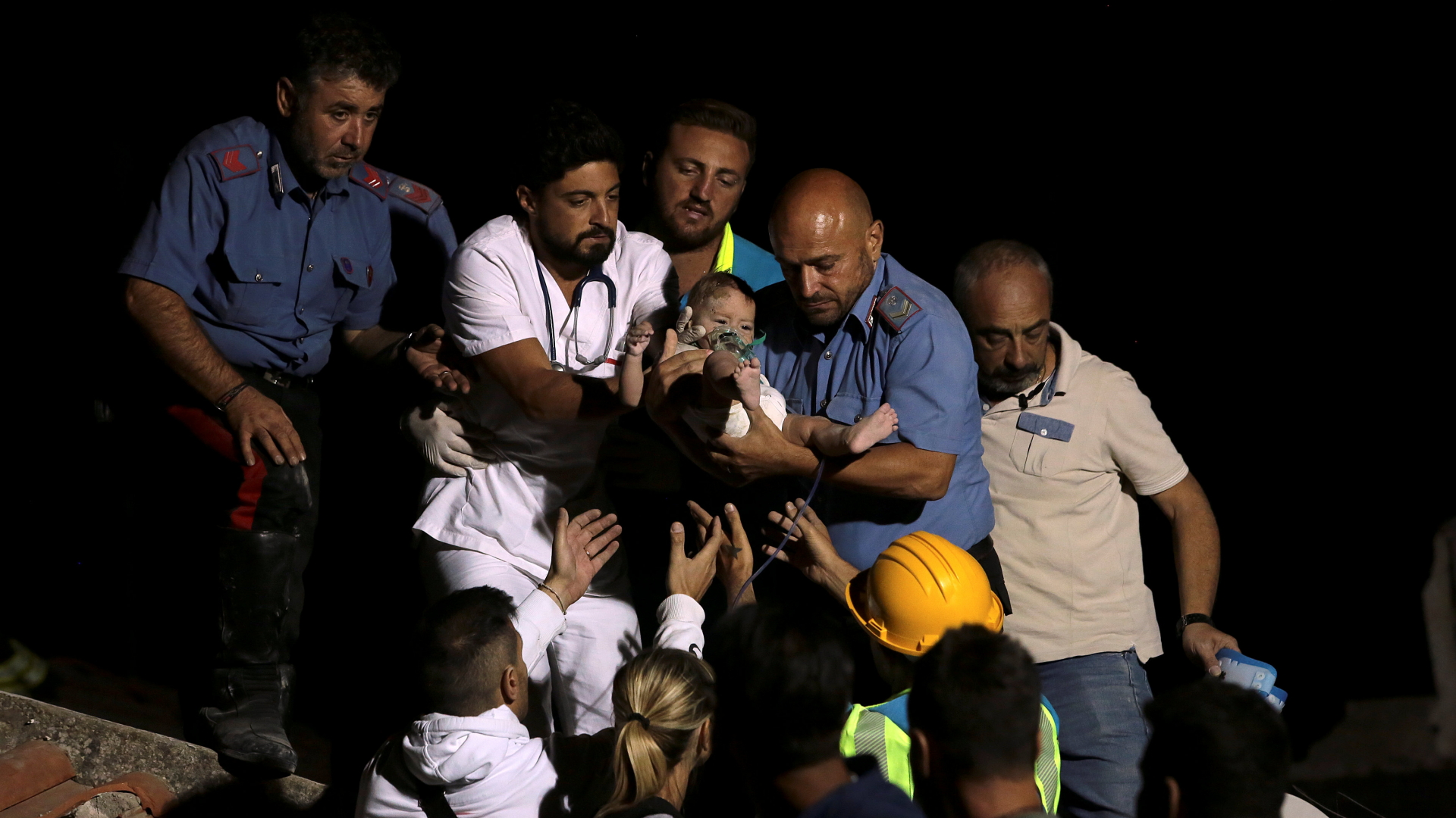 Rettungskräfte tragen ein Kind aus den Trümmern in Ischia. | REUTERS