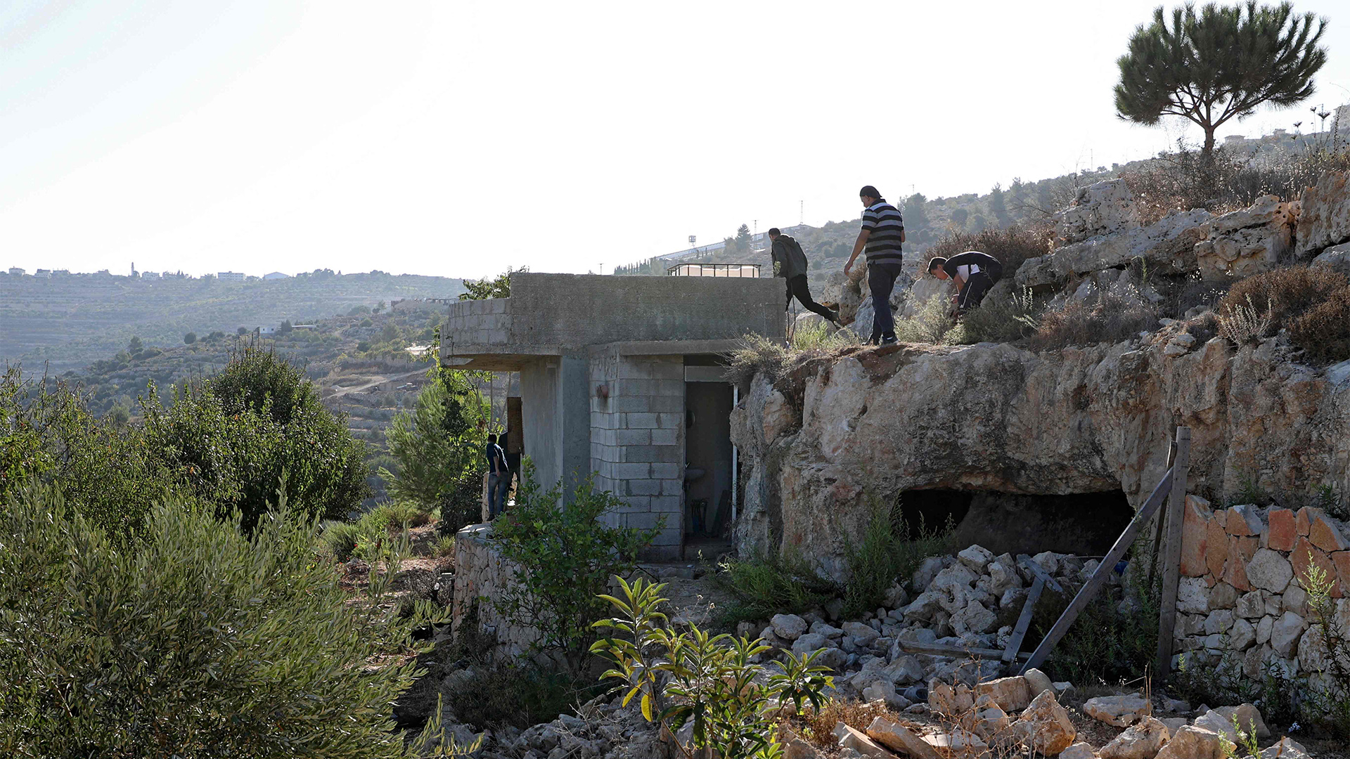 Menschen begutachten den Ort, an dem drei Palästinenser getötet wurden. | AFP