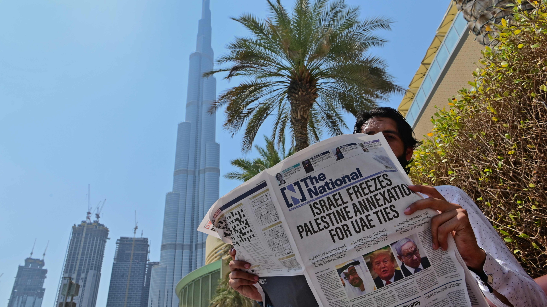 In Mann liest in Dubai eine Zeitung mit der Schlagzeile "Israel stoppt die Annexion zur Aufnahme diplomatischer Beziehungen zu den Vereinigten Arabischen Emiraten". | AFP