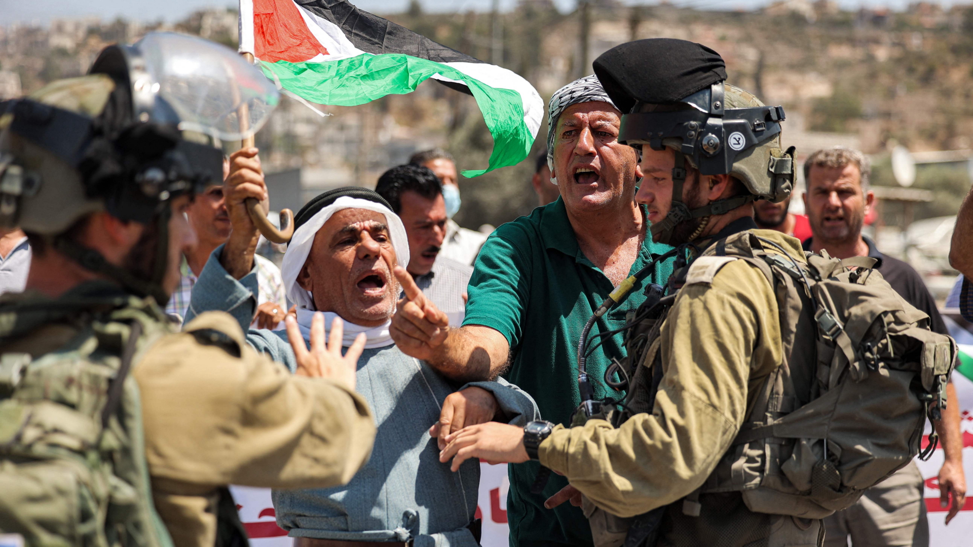 Israelische Soldaten diskutieren mit Palästinensern im Westjordanland. | AFP
