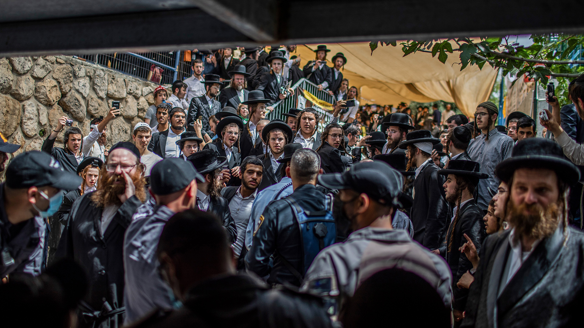 Orthodoxe Juden haben sich vor Sicherheitskräften an der Unglücksstelle, der jüdisch-orthodoxen Pilgerstätte auf dem Berg Meron versammelt. | dpa