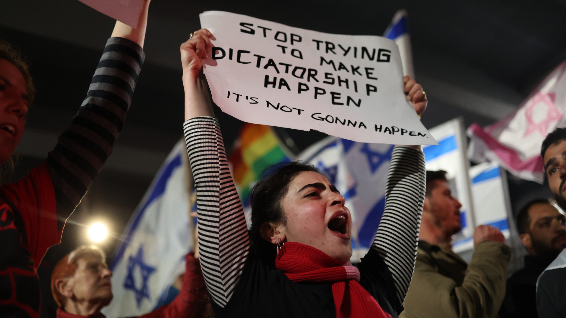Eine Protestierende hält ein Plakat mit der Aufschrift "Stop trying to make diktatorship happen" in die Höhe.  | Foto: Ilia Yefimovich/dpa Bildfunk