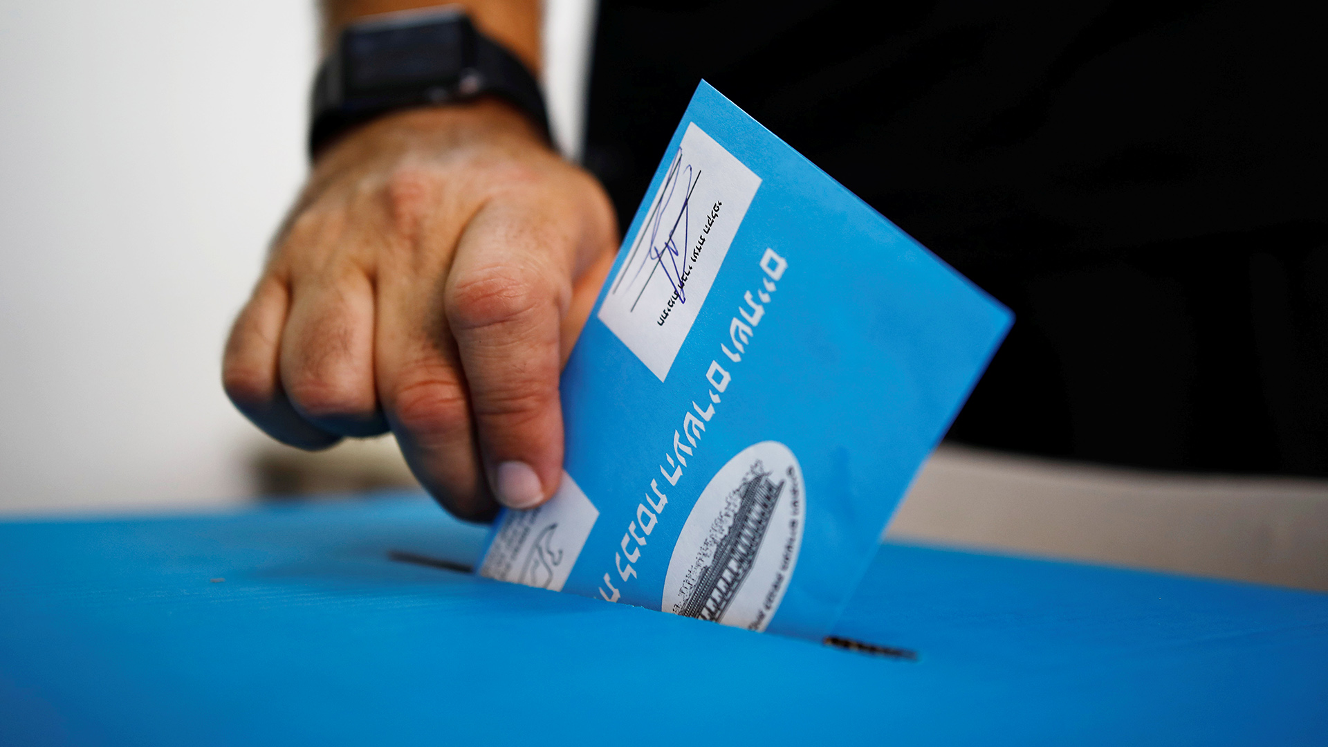 Ein Mann wirft in Tel Aviv einen Umschlag mit dem Wahlzettel in eine Urne