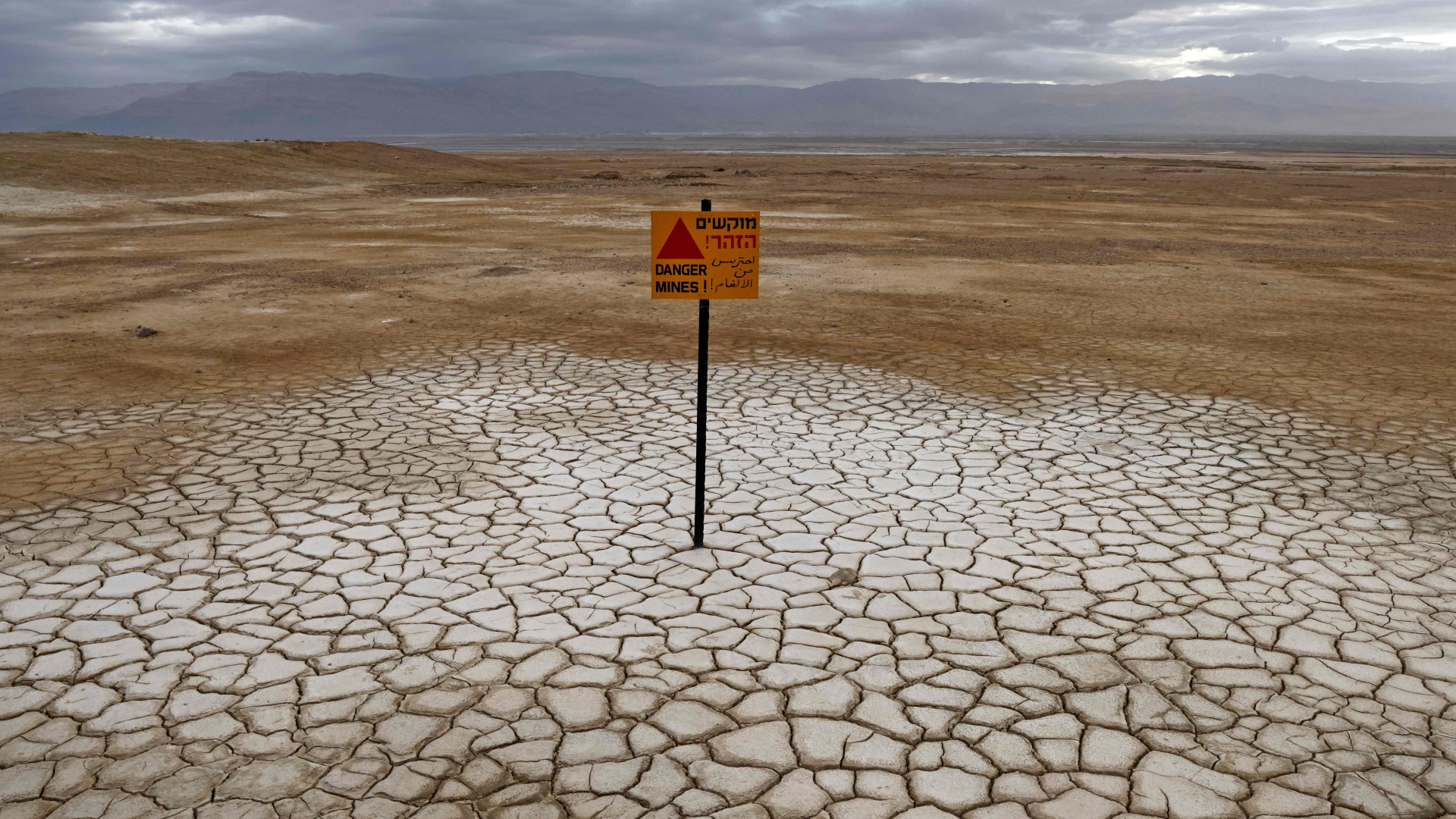 Ein Schild warnt vor Minen, wo sonst das Wasser des Tote Meers den Boden bedeckt. | AFP